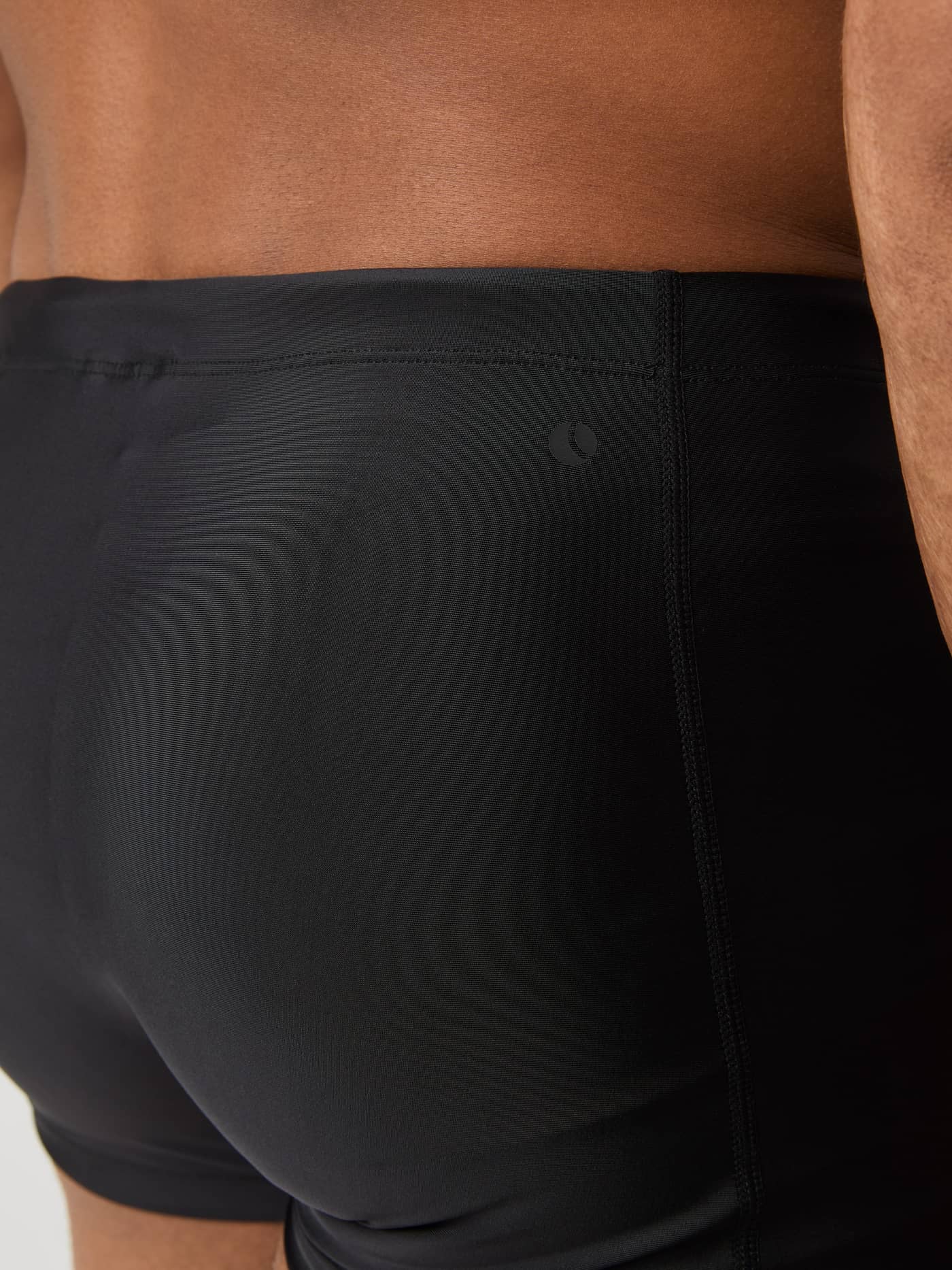 Detailed close-up of the Borg Swim Trunks in Black Beauty (Black), showcasing the slim fit and logo for pool training. - Image 5