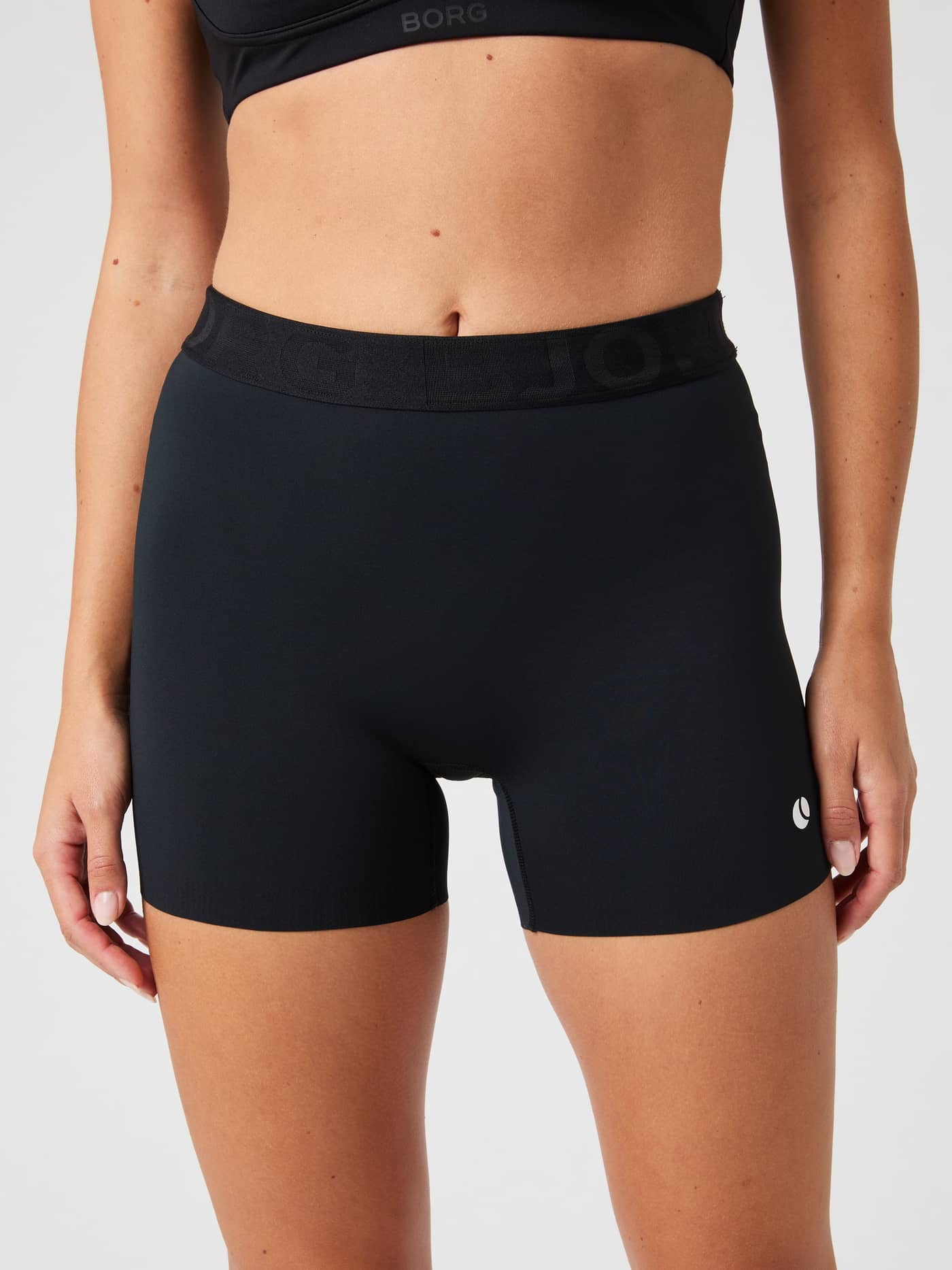 Front view of a model wearing the Ace Short Shorts in Black Beauty (Black), featuring a high-waisted fit for tennis. - Image 1