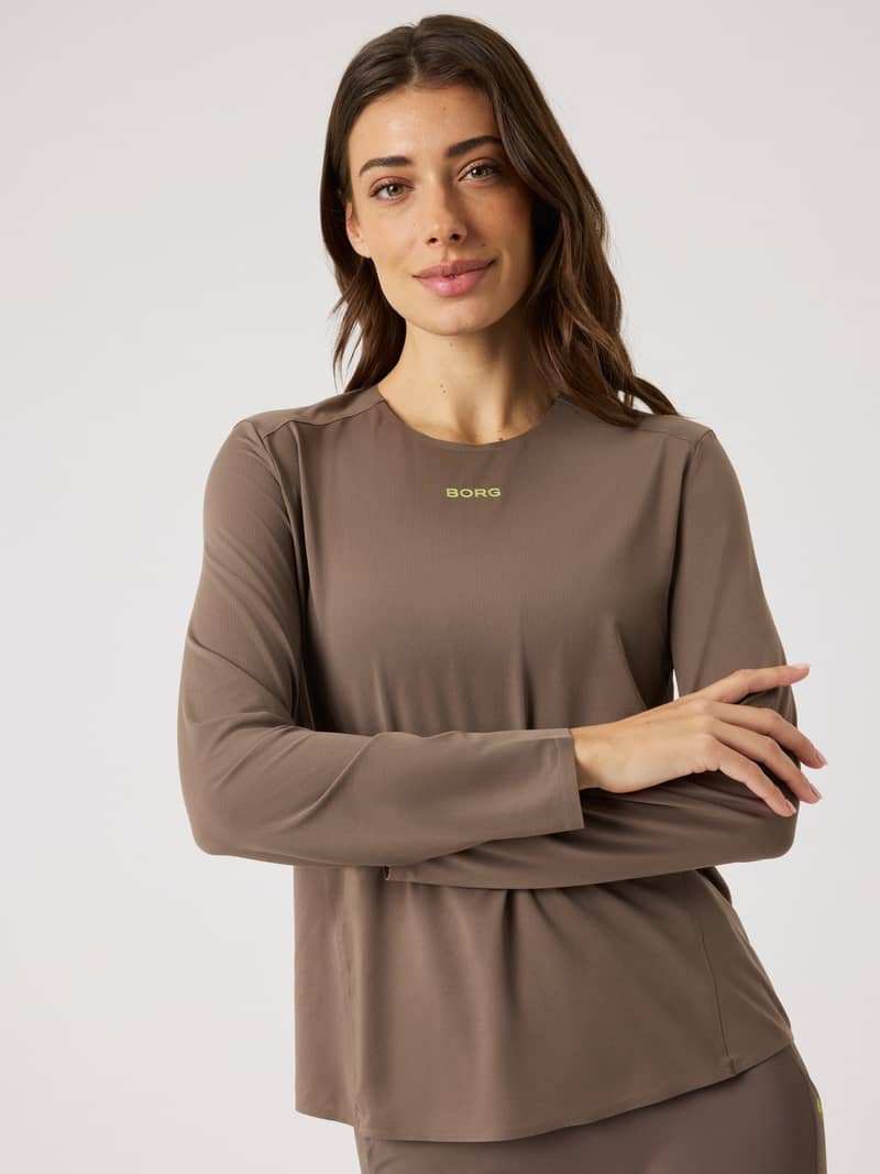 Front view of a model in the Falcon (Brown) Borg Running Feather Long Sleeve T-Shirt featuring a lime green logo.
