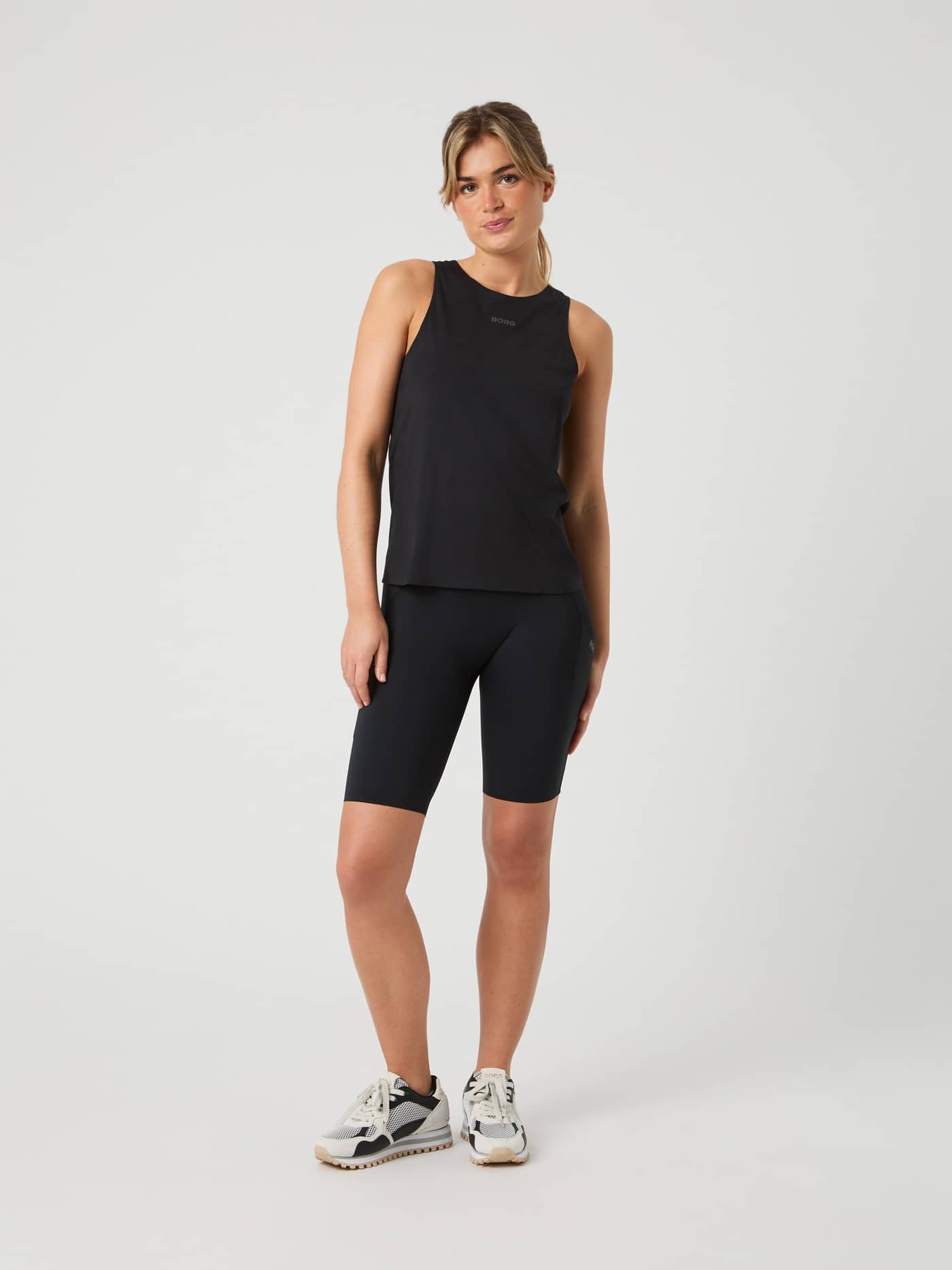 Full-body front view of a woman wearing the stylish Borg Running Feather Tank in Black Beauty (Black) for running. - Image 3