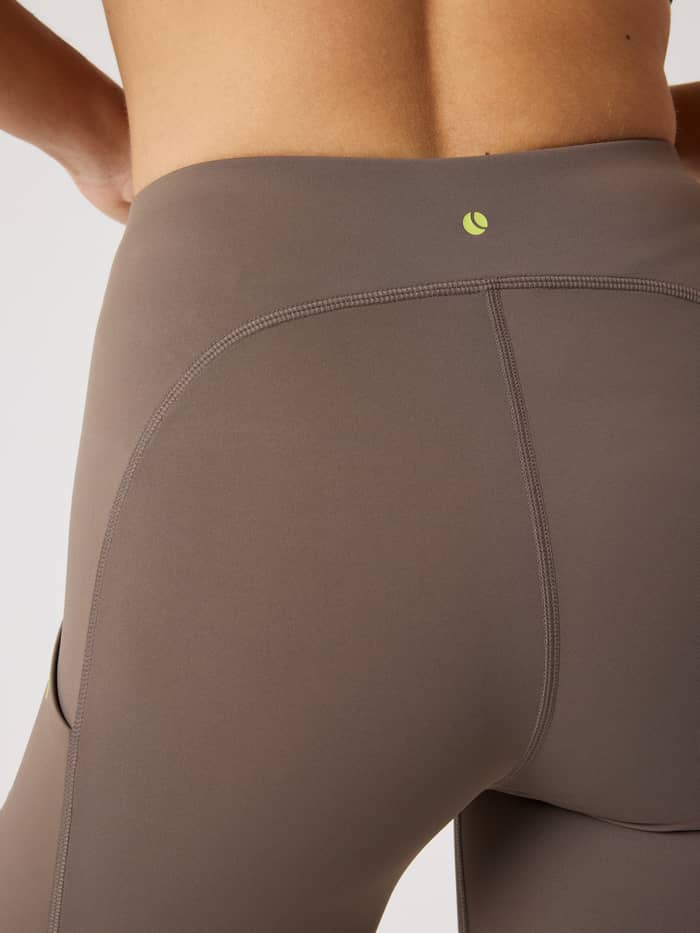 Detailed back view of the slim-fit Borg Performance Short Tights in Falcon (Brown) for running with a lime green logo. - Image 4
