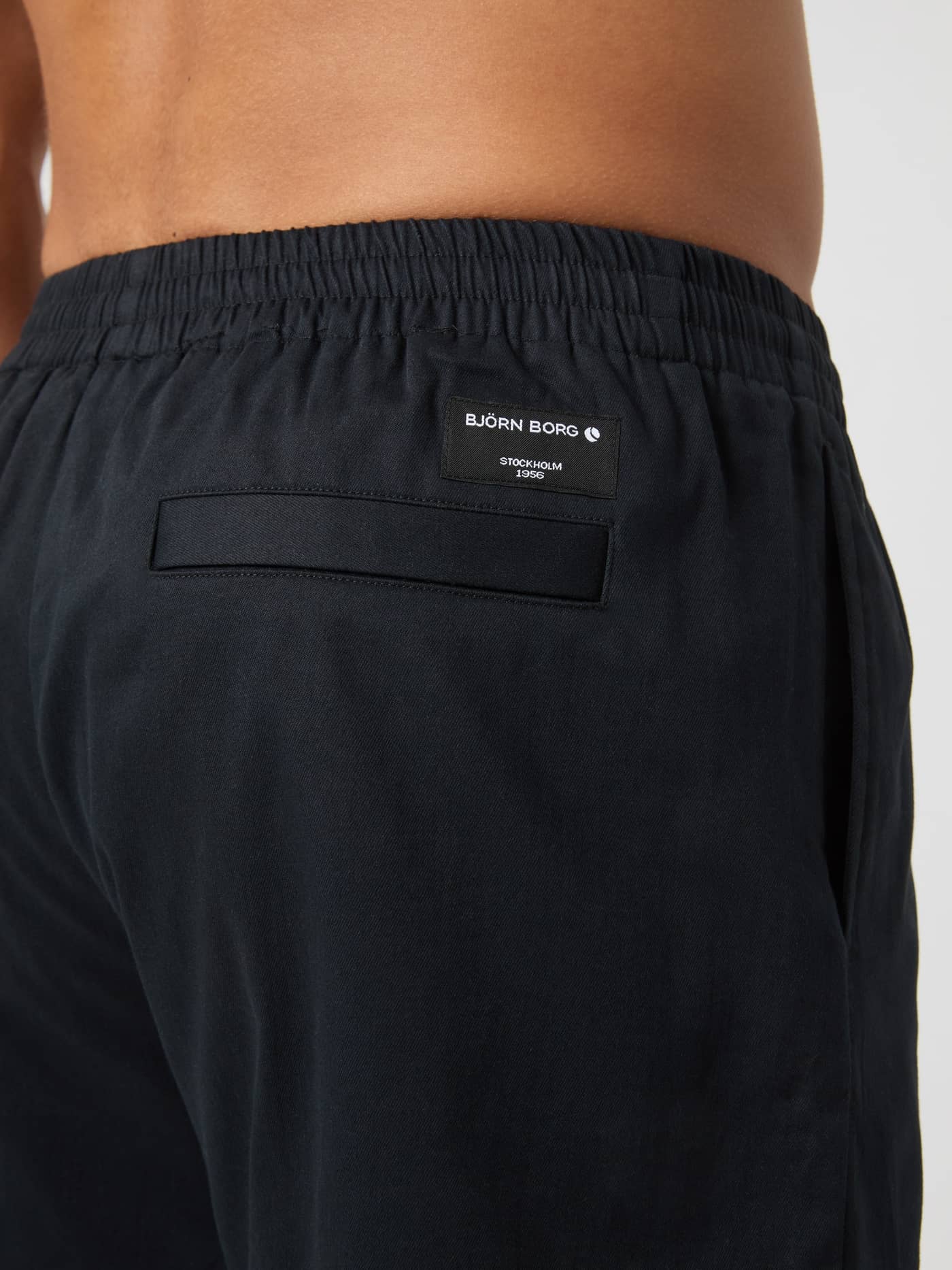 Rückansicht der Centre Woven Drawstring Shorts in Black Beauty (Schwarz) mit weißem Logo-Etikett und Gesäßtasche. - Image 3