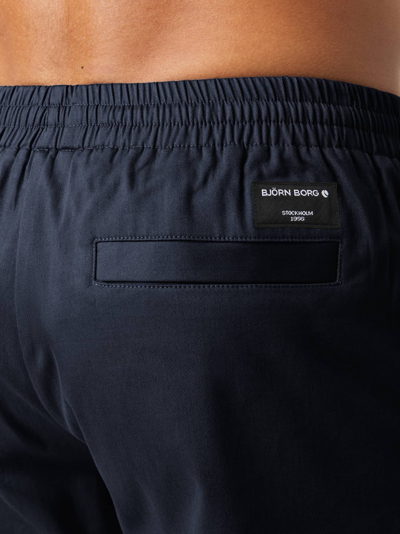 Back view close-up of the Centre Woven Drawstring Shorts in Night sky (Navy), showing the back pocket and black logo label. - Image 5