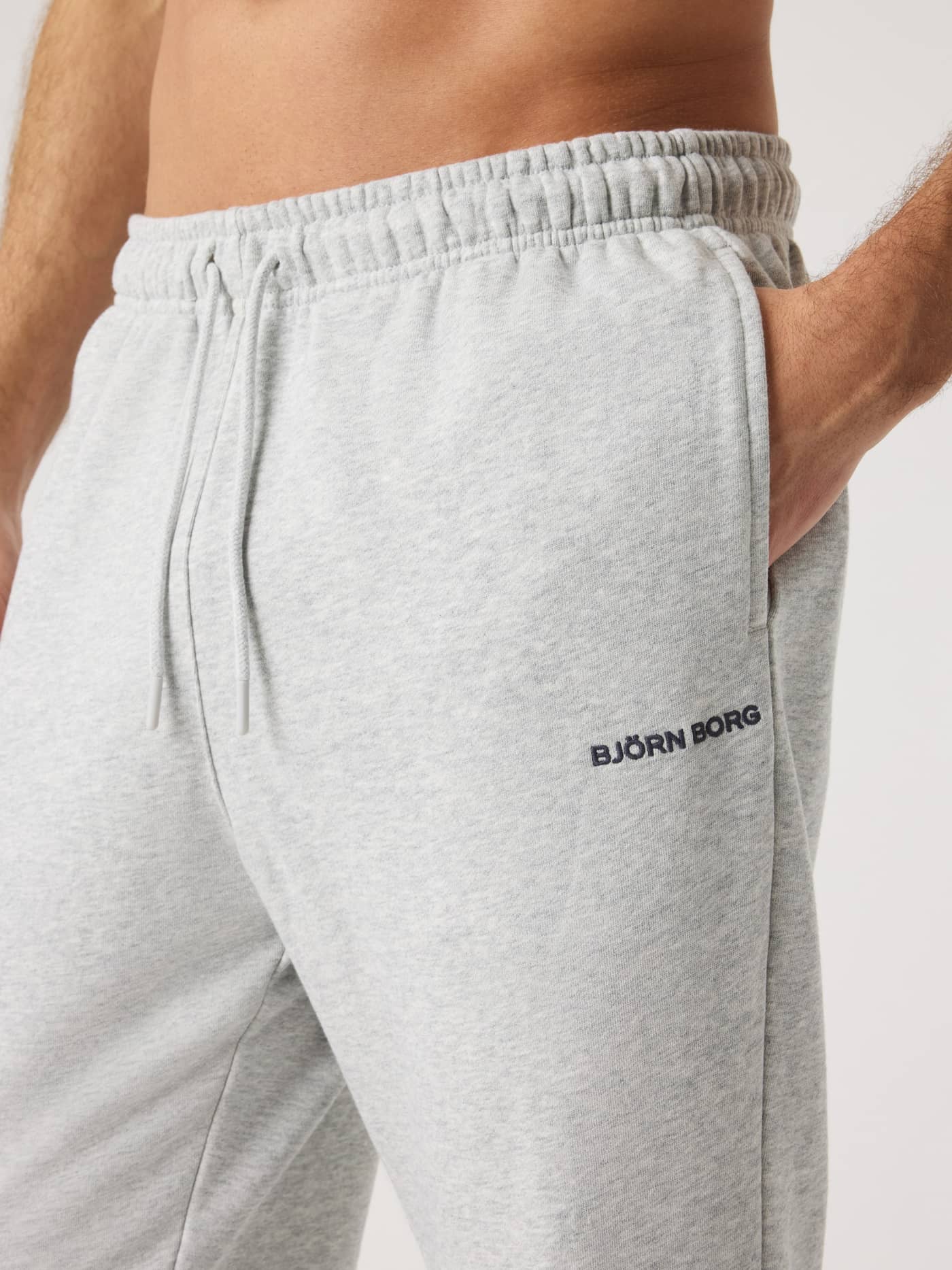 Nahaufnahme der Borg Classic Sweatpants für Herren in Ultra Light Grey Melange (Grau) aus Baumwolle mit dunklem Logo. - Image 6