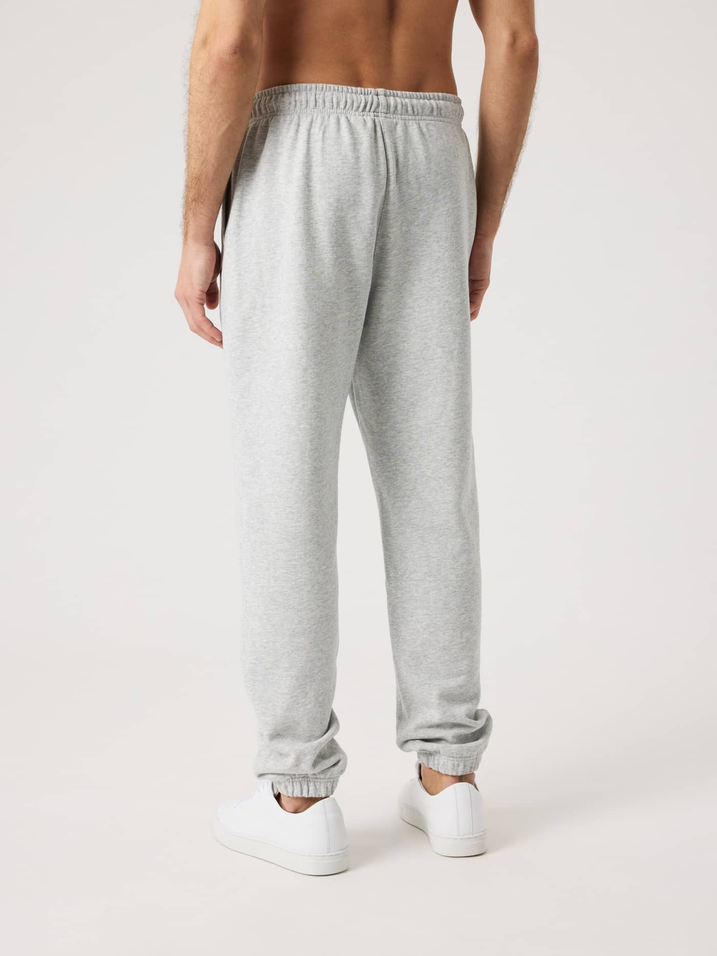 Rückansicht eines Mannes in der Borg Classic Sweatpants in Ultra Light Grey Melange (Grau) mit normaler Passform. - Image 3