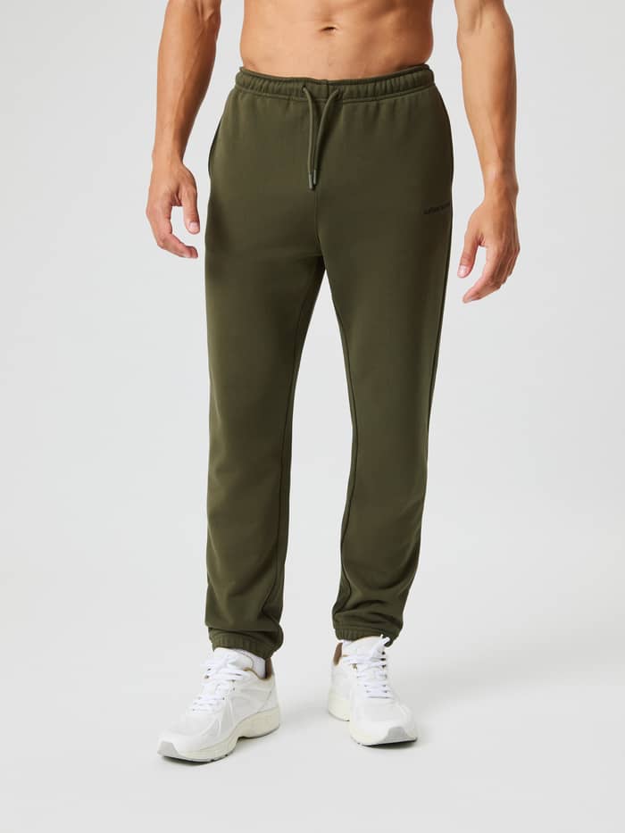 Vooraanzicht van een man in de Borg Classic Sweatpants in Forest Night (Groen) met trekkoord en zwart logo. - Image 2