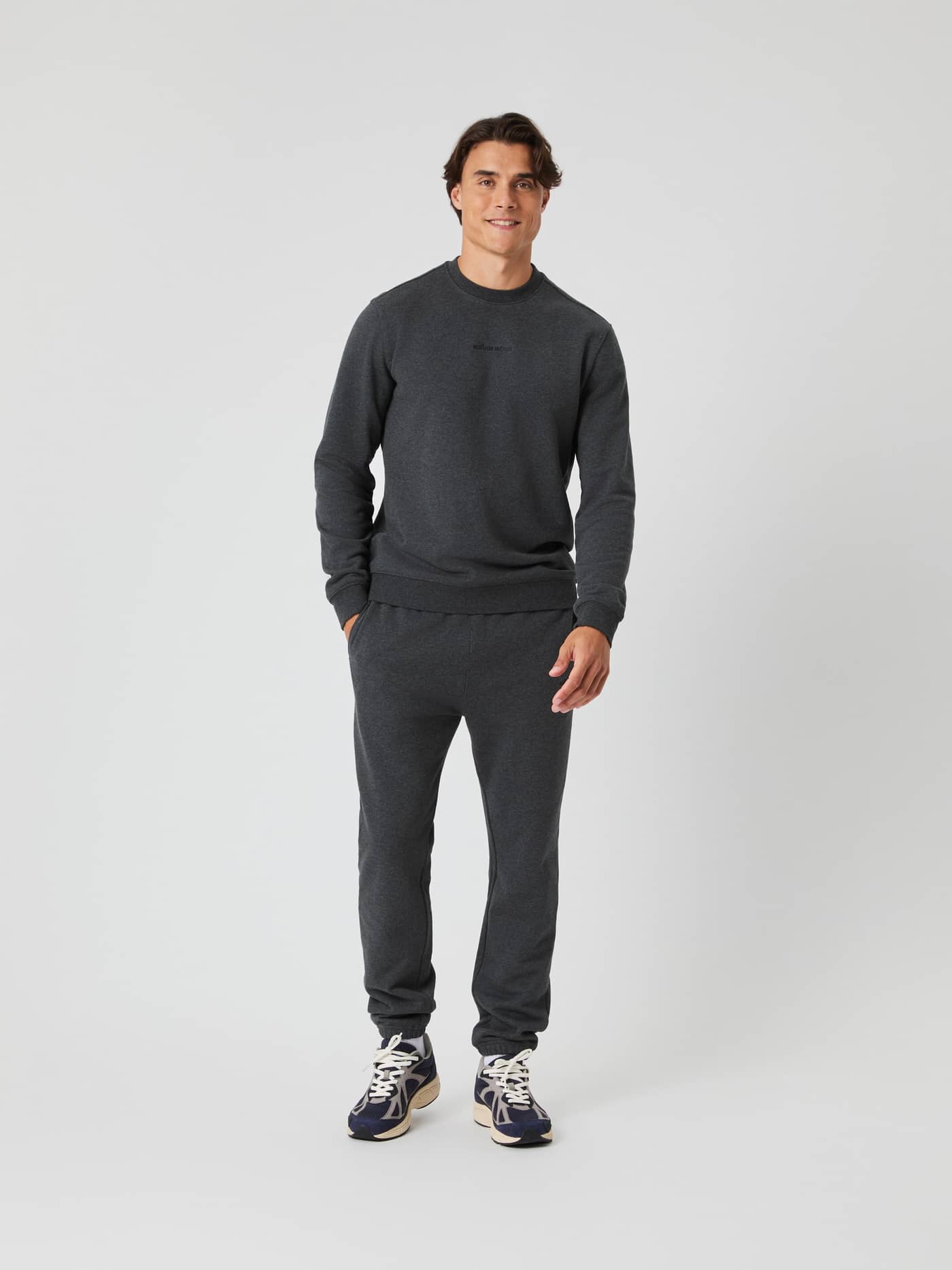 Borg Classic Sweatpants i Dark Gray Melange (Grå) set forfra på en mand i blødt french terry med en matchende overdel. - Image 1