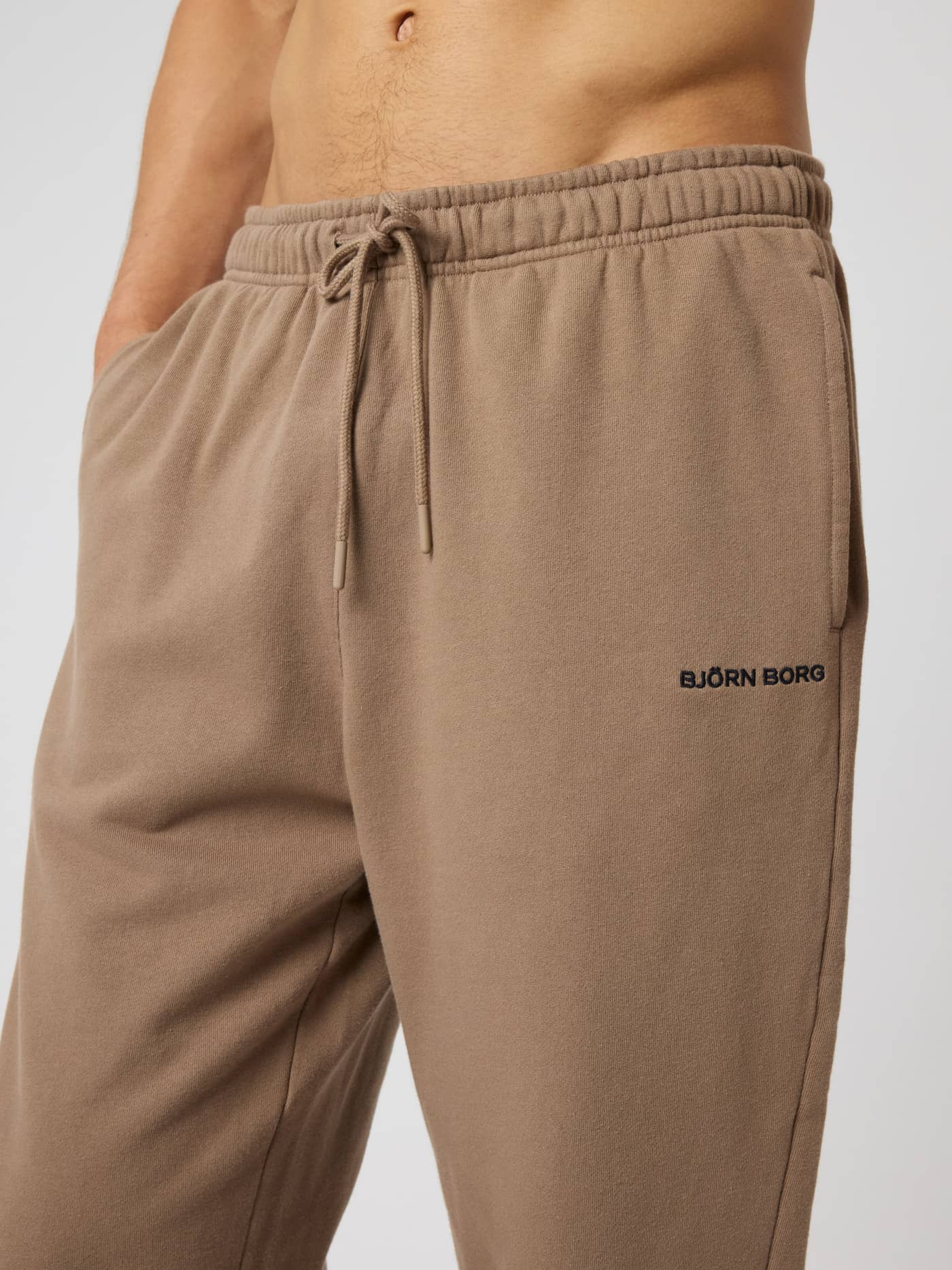 Close-up of the cotton Borg Classic Sweatpants in Caribou (Brown) featuring a black embroidered logo and drawstring waist. - Image 5