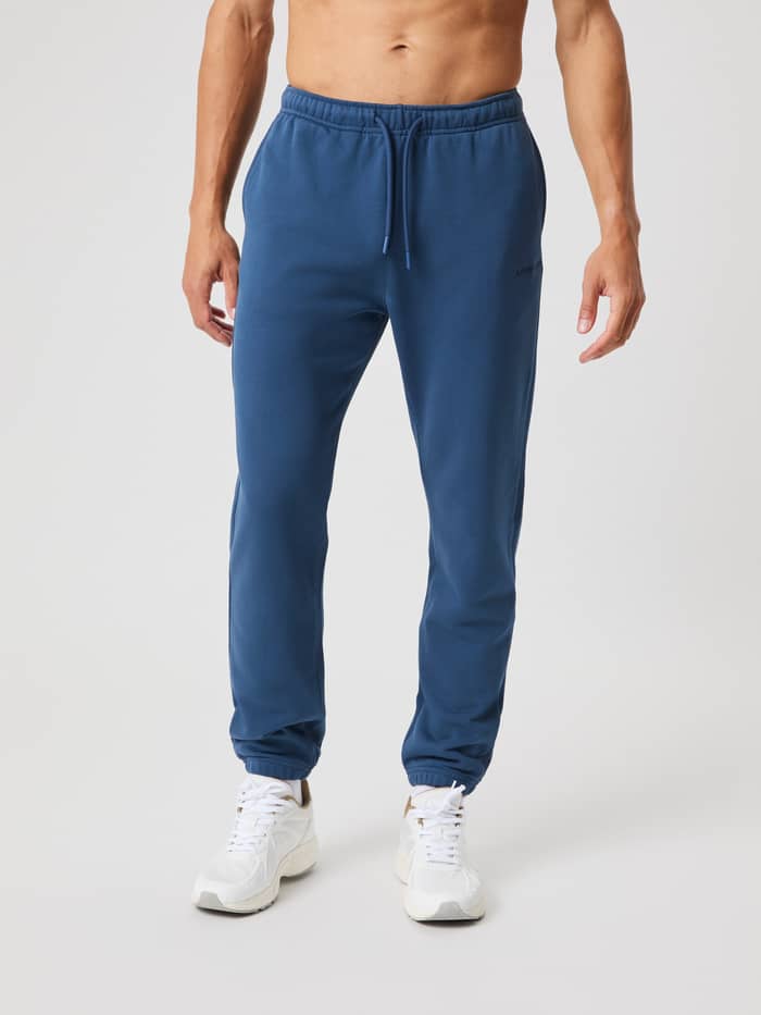 Front view of a man wearing the Borg Classic Sweatpants in Sargasso Sea (Blue), made from soft cotton French terry. - Image 2
