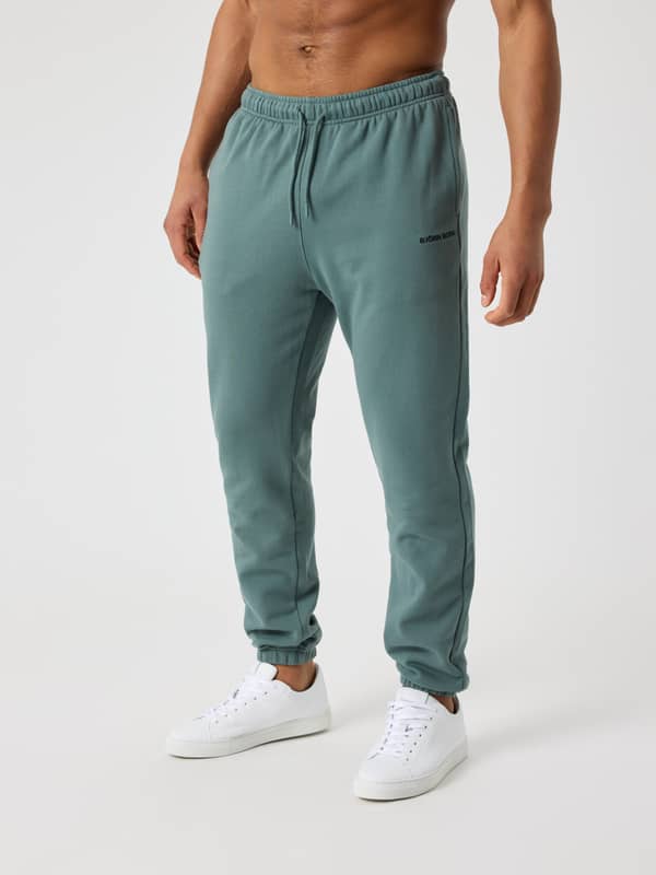 Vue de face d'un homme portant le Borg Classic Sweatpants en Balsam Green (Vert), coupe regular en coton et logo noir.