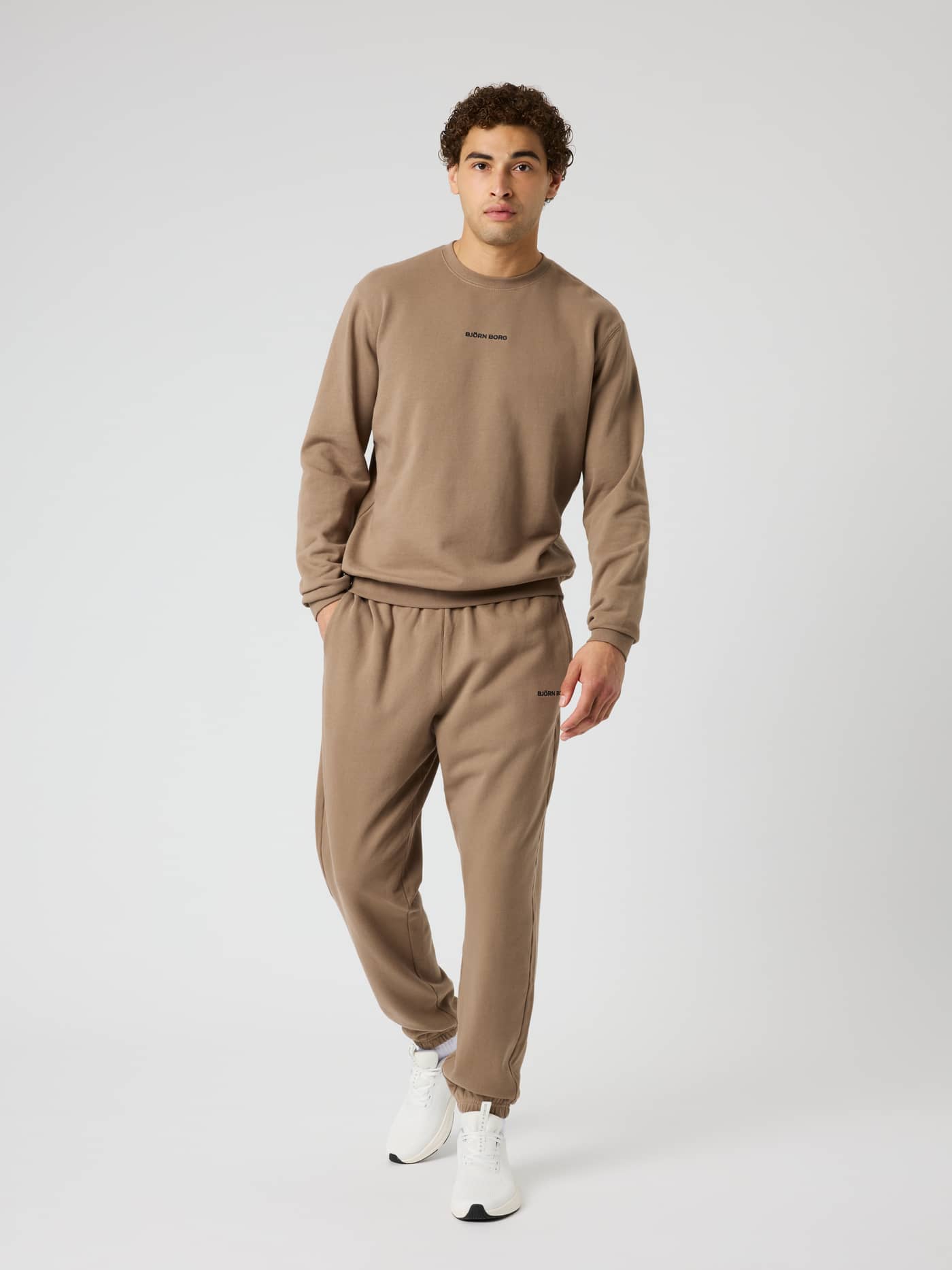 Borg Classic Sweatpants in Caribou (Brown) on a model, featuring a black logo and ribbed cuffs in soft cotton. - Image 4