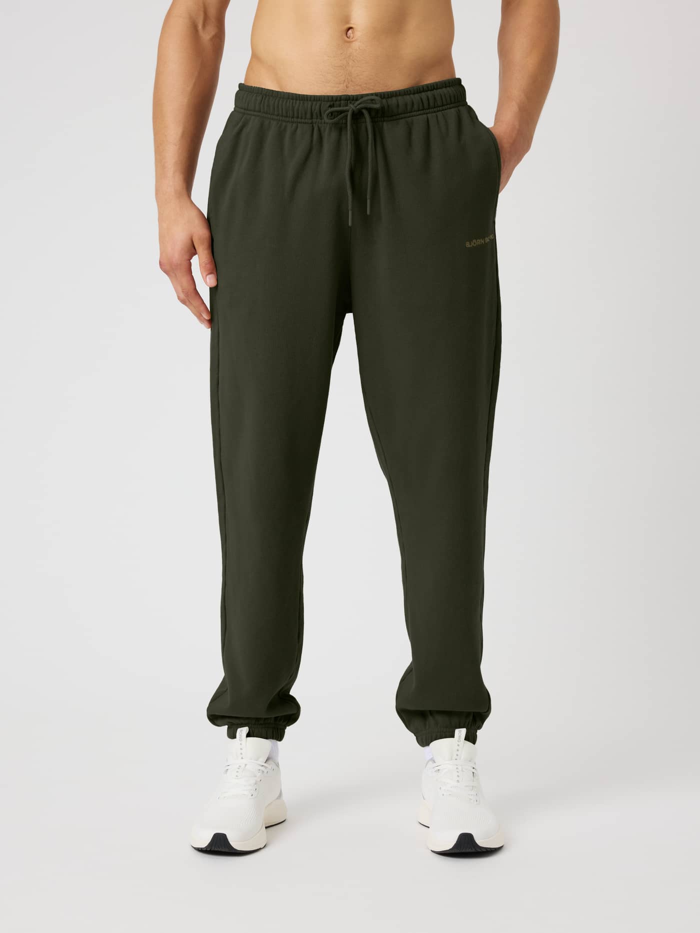 Front view of a model wearing Borg Classic Sweatpants in Rosin (Green) made from soft cotton French terry. - Image 1