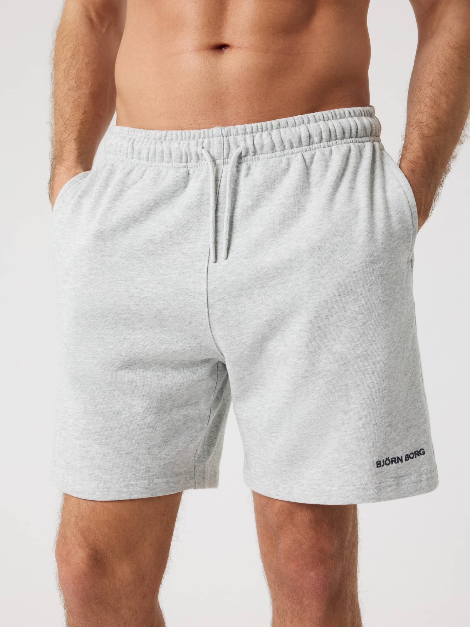 Vue de face d'un homme portant le Borg Classic Sweatshorts en coton Ultra Light Grey Melange (Gris) avec logo noir. - Image 1