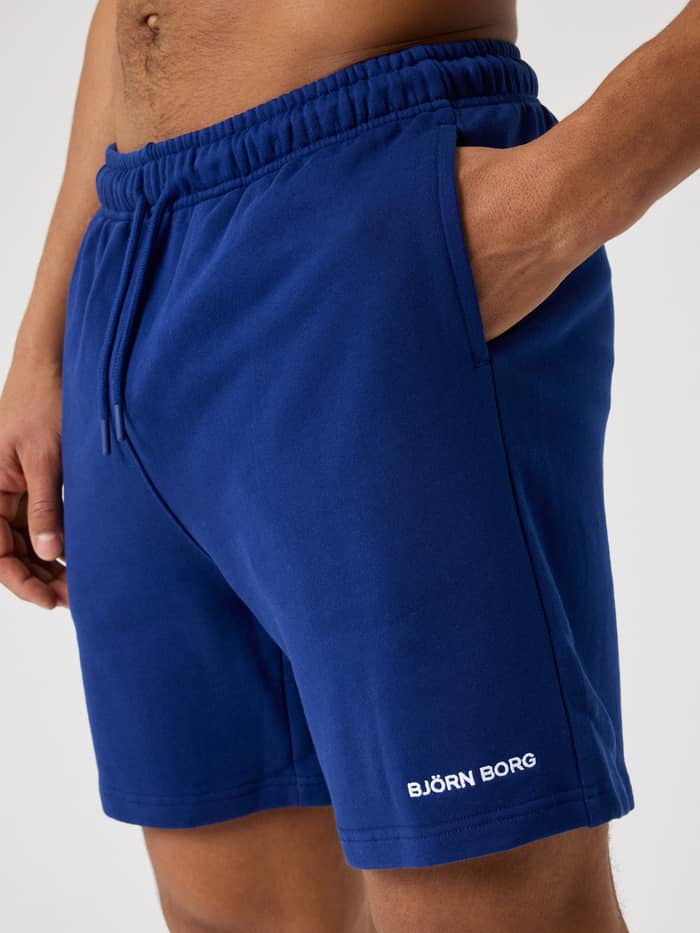 Close-up of a man wearing Blue Depths (Blue) Björn Borg Classic Sweatshorts in cotton French terry with a white logo.