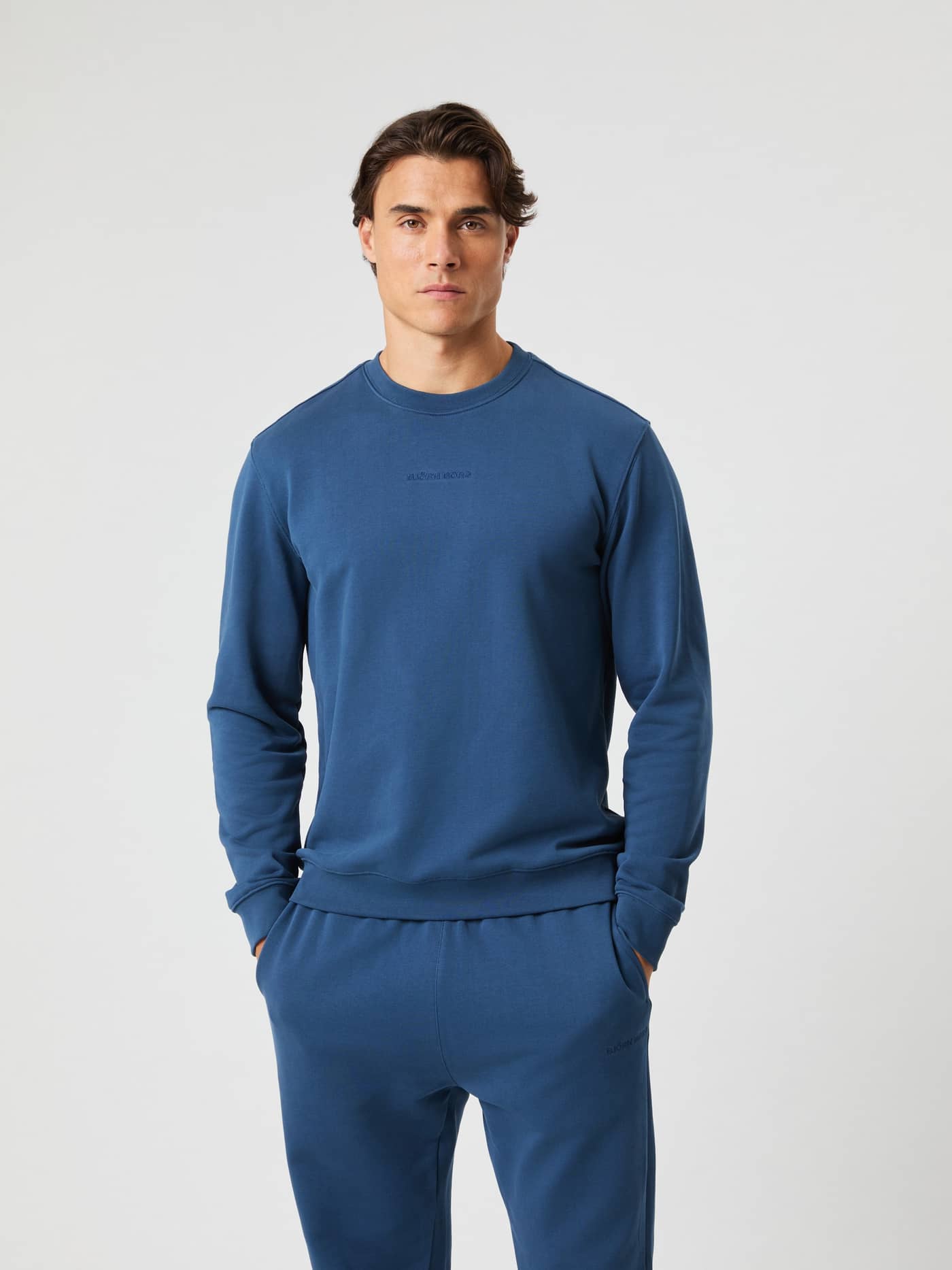 Front view of a model wearing the cotton French terry Borg Classic Sweatshirt in Sargasso Sea (Blue) with a regular fit. - Image 1