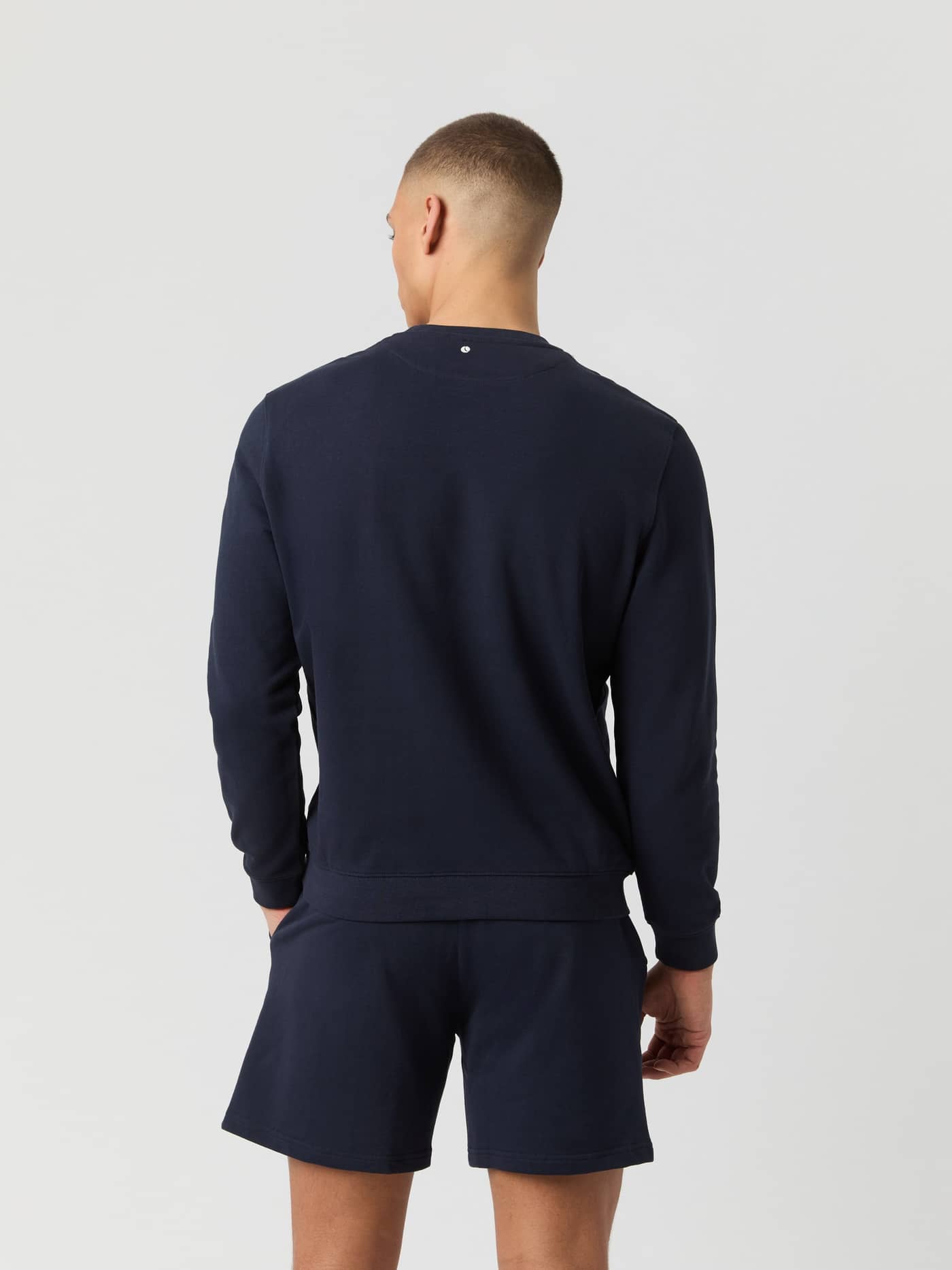 Back view of a man wearing the regular fit cotton Björn Borg Classic Sweatshirt in Night sky (Navy) with a white logo. - Image 2