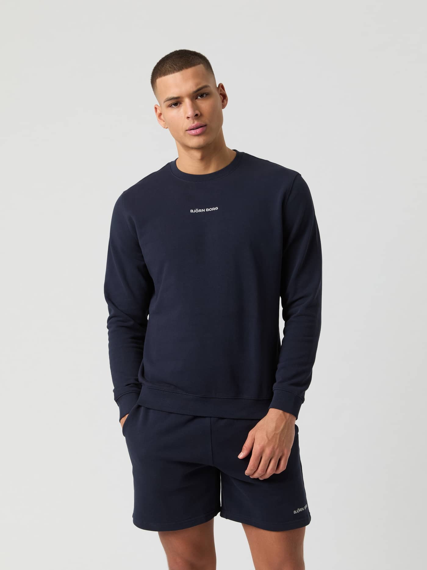 Vooraanzicht van man in het Borg Classic Sweatshirt in Night sky (Marineblauw) van 100% katoenen french terry met wit logo. - Image 1