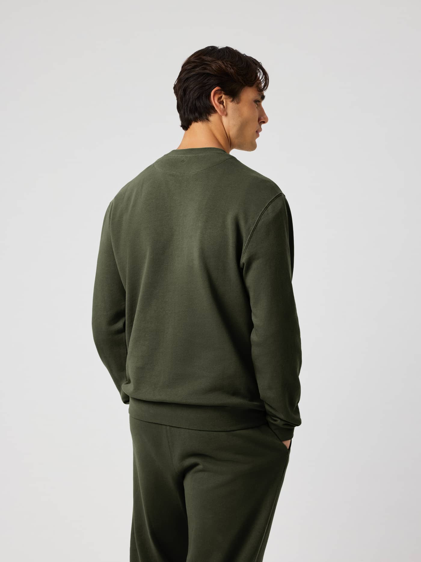 Back view of a man wearing the Borg Classic Sweatshirt in Rosin (Green), a soft cotton French terry sweater for tennis. - Image 3
