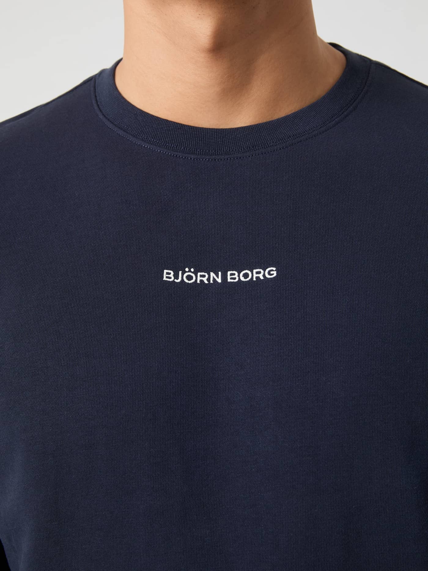 Close-up of the cotton French terry Borg Classic Sweatshirt in Night sky (Navy) with a white embroidered logo. - Image 5