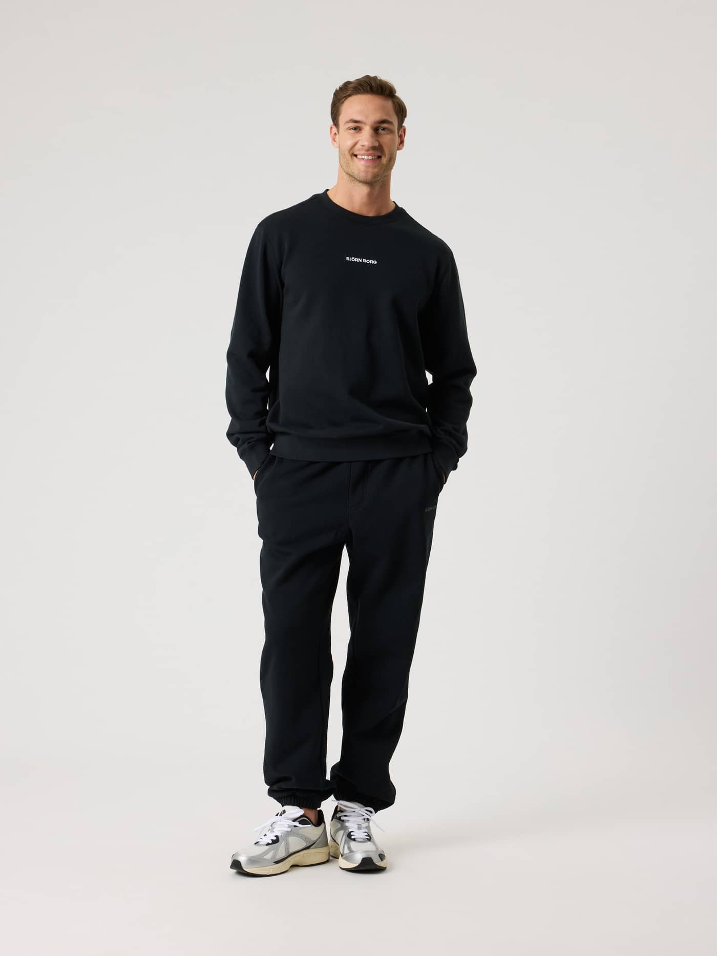 Full-body front view of a man wearing the cotton Björn Borg Classic Sweatshirt in Black Beauty (Black) with a white logo. - Image 3