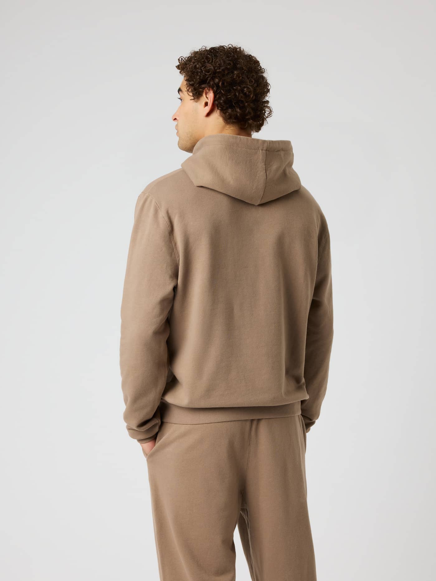 Back view of a man wearing the Borg Classic Hoodie in Caribou (Brown) made of soft cotton for training sessions. - Image 3