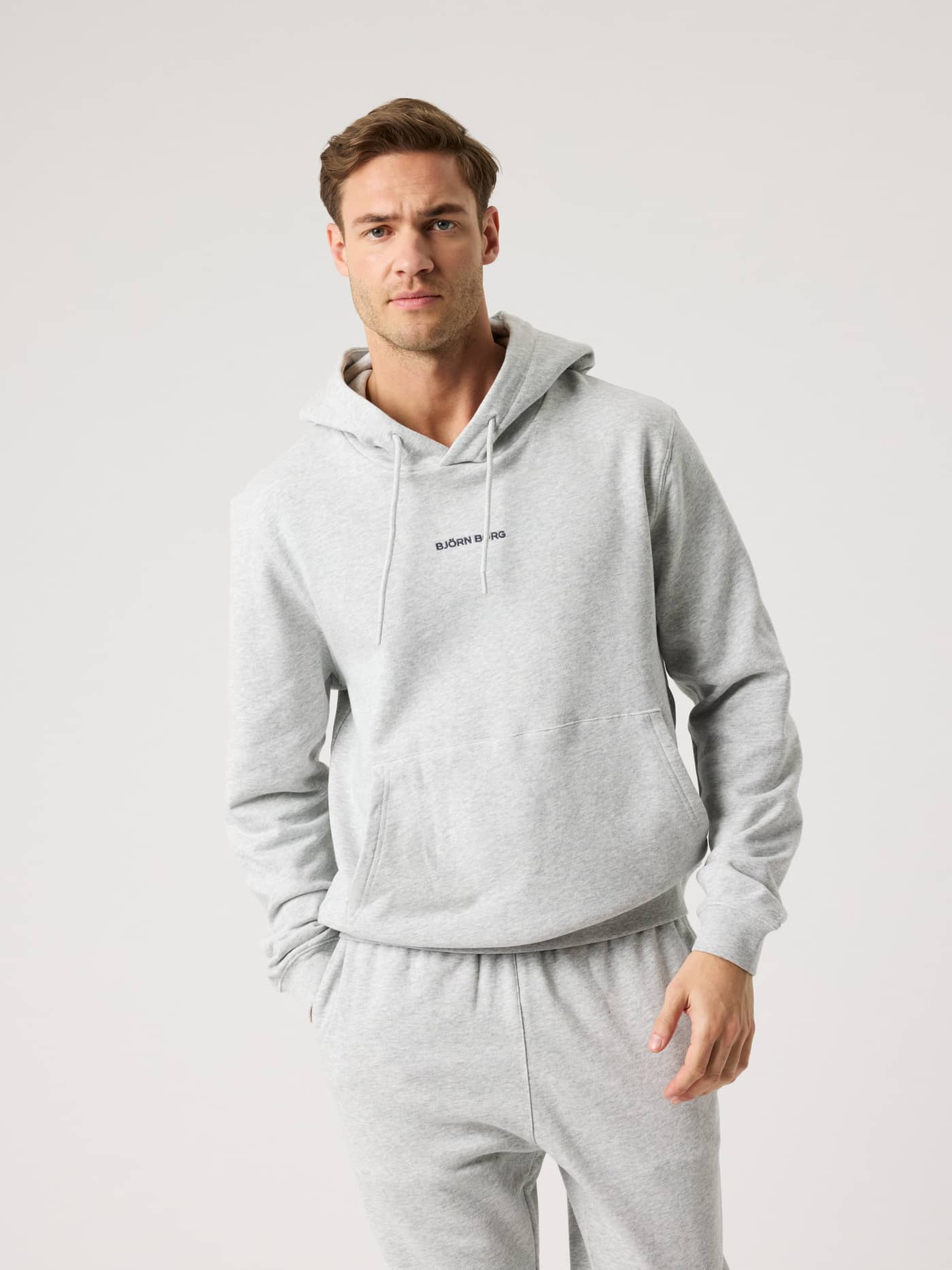 Borg Classic Hoodie i Ultra Light Grey Melange (Grå) sett forfra på mann, i bomull med svart logo for stil og funksjon. - Image 1