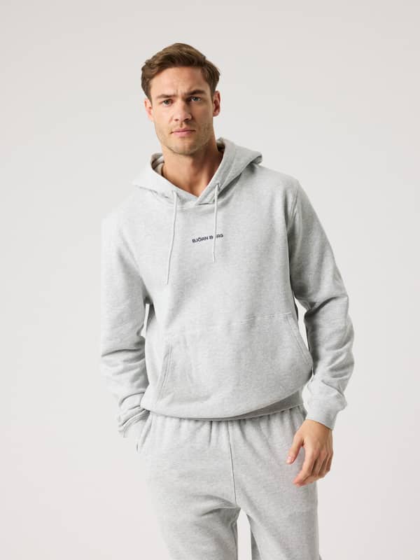 Vue de face d'un homme portant le Borg Classic Hoodie en coton Ultra Light Grey Melange (Gris) avec logo brodé noir.