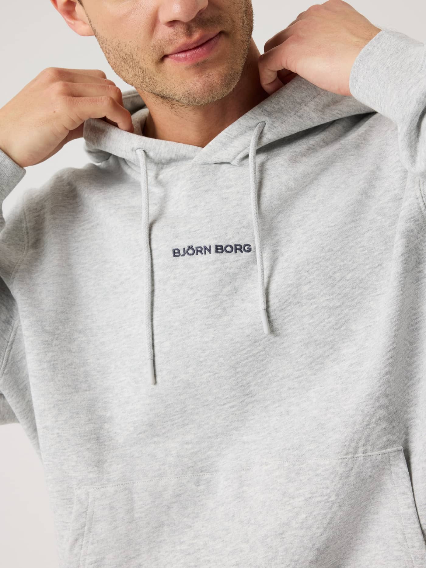 Front view of the regular fit Borg Classic Hoodie in Ultra Light Grey Melange (Grey) with navy chest logo embroidery. - Image 5