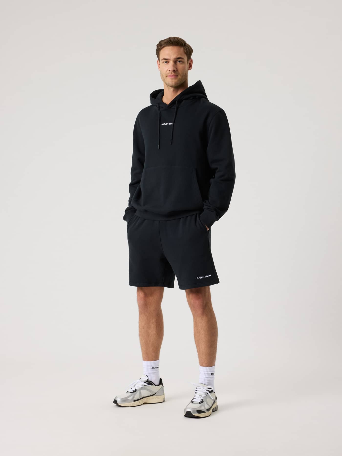Full-body front view of a man wearing the Björn Borg Borg Classic Hoodie in Black Beauty (Black) for style and training. - Image 4