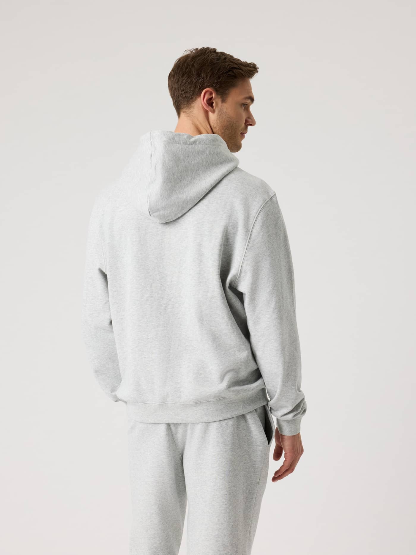 Back view of a man wearing the Borg Classic Hoodie in Ultra Light Grey Melange (Grey) in a soft and comfortable regular fit. - Image 2