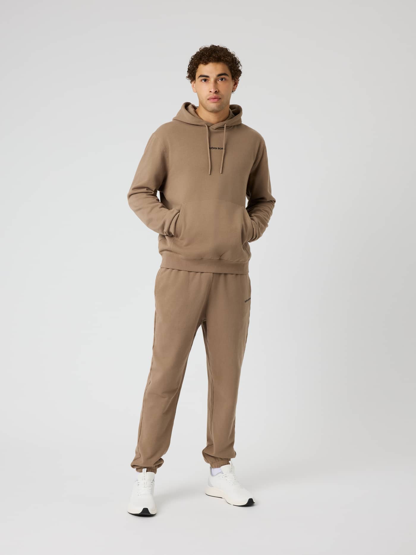 Full-body front view of a model wearing the Borg Classic Hoodie in Caribou (Brown) with a black logo for training. - Image 4