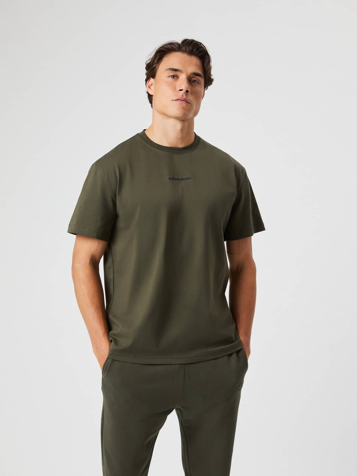 Front view of a man wearing the cotton Borg Classic T-Shirt in Forest Night (Green) with a black logo and tennis style. - Image 1