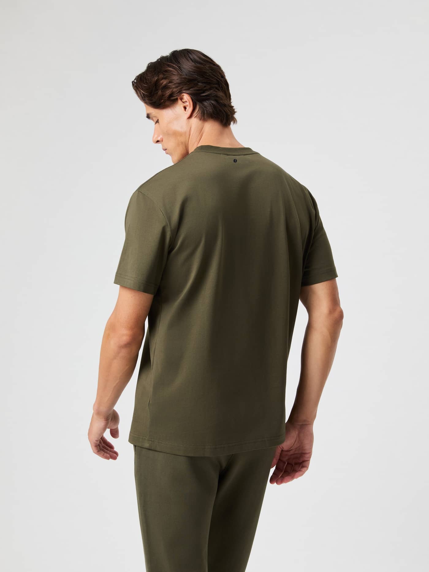 Back view of a man wearing the cotton Borg Classic T-Shirt in Forest Night (Green) with a tennis logo detail. - Image 2