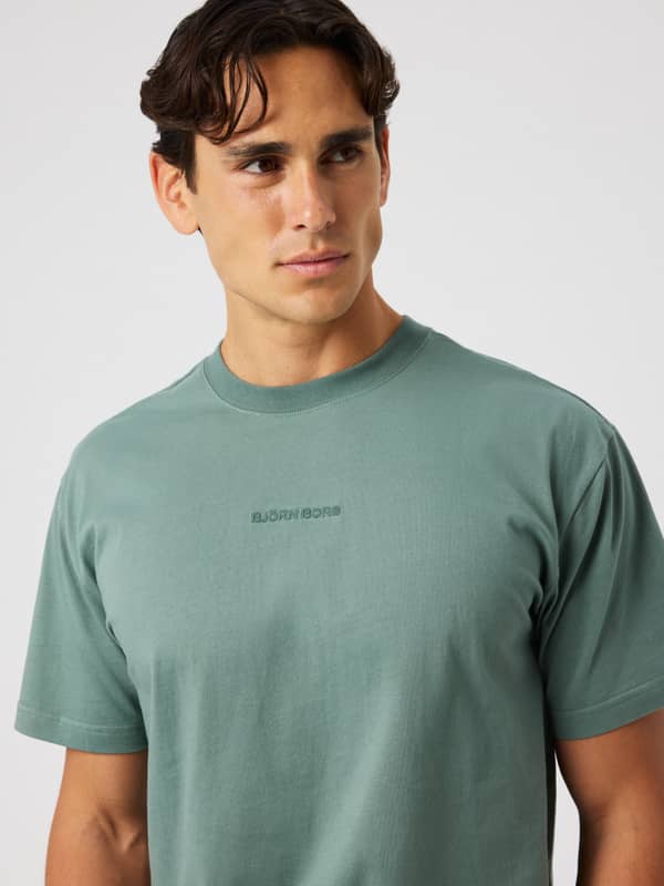 Man wearing the Borg Classic T-Shirt in Laurel Wreath (green) featuring a matching embroidered front logo.