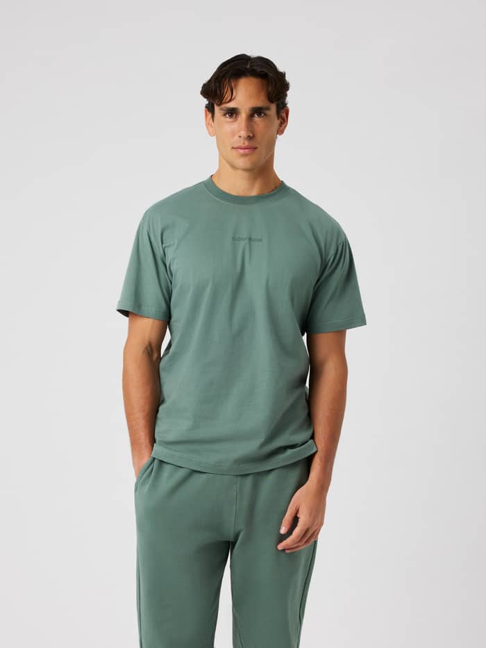 Man wearing the Borg Classic T-Shirt in Laurel Wreath (green) featuring a ribbed round neck and embroidered front logo.