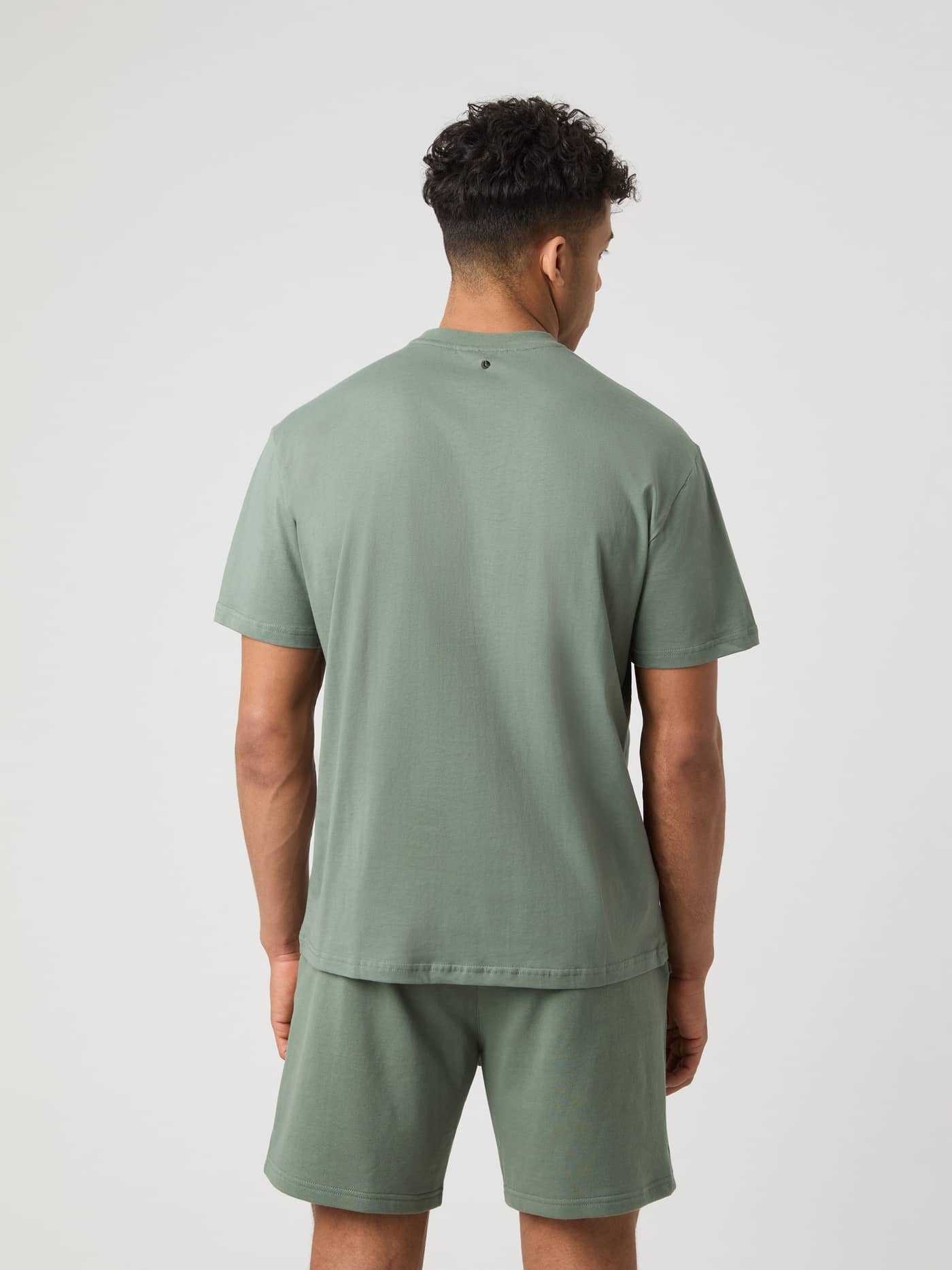 Achteraanzicht van een man in het katoenen Borg Classic T-Shirt in Agave Green (Groen) met zwart geborduurd tennisballenlogo. - Image 2