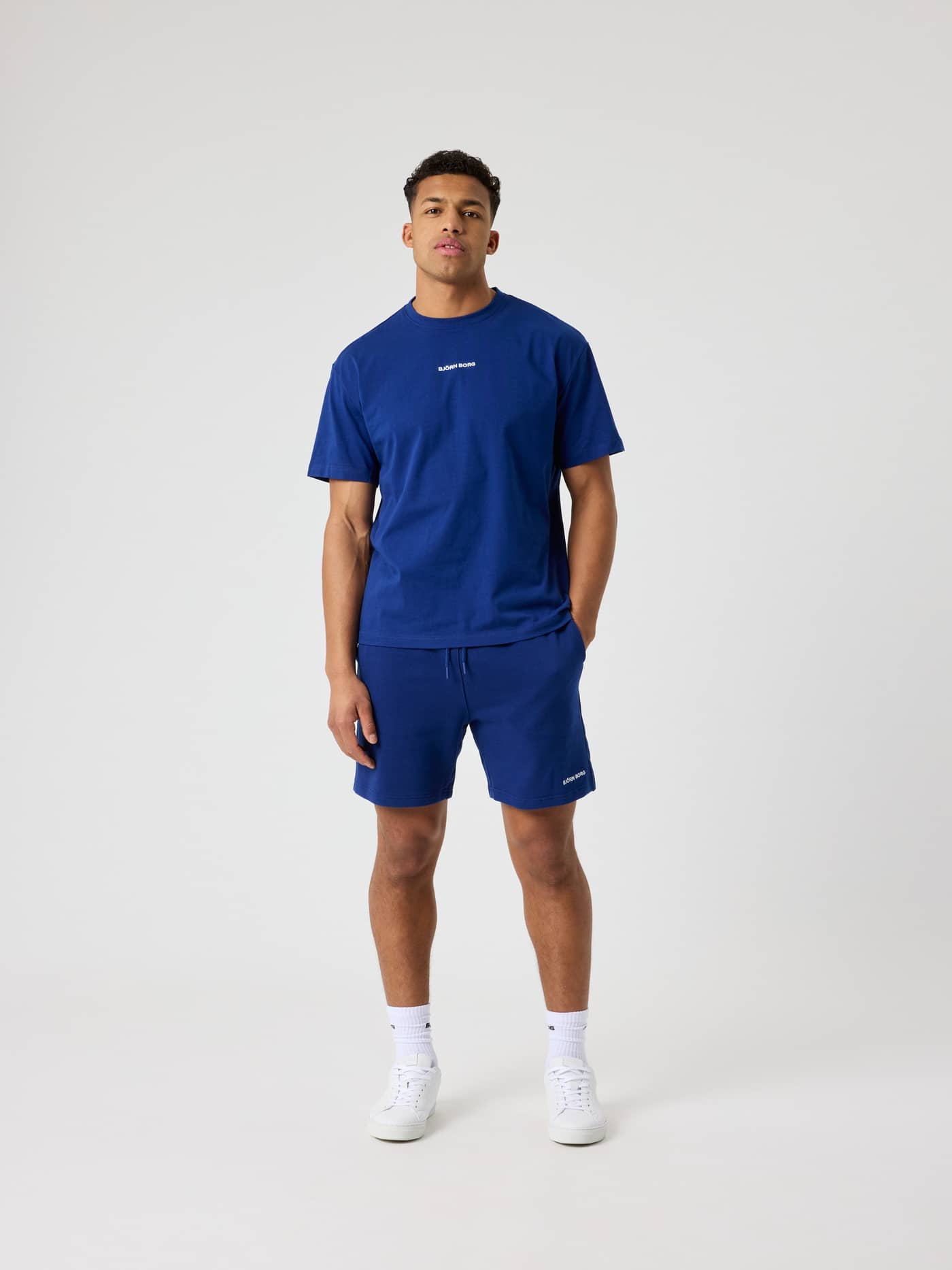 Vorderansicht eines Mannes im Borg Classic T-Shirt in Blue Depths (Blau) aus Baumwolle mit weißem Logo und normaler Passform. - Image 3