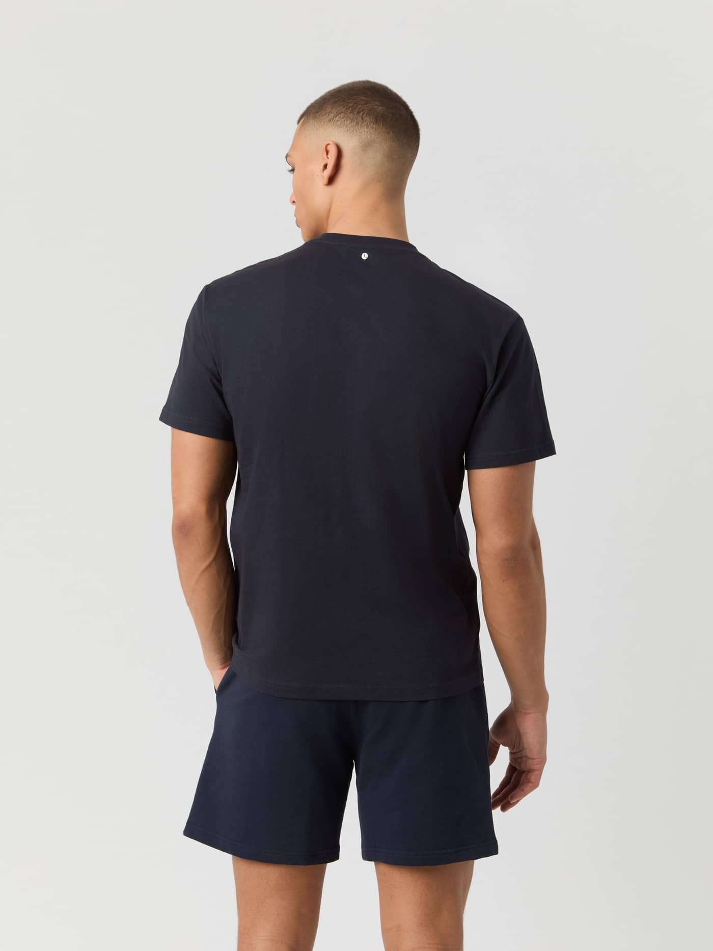 Back view of a man wearing the cotton Borg Classic T-Shirt in Night sky (Navy) with a small tennis ball logo. - Image 2