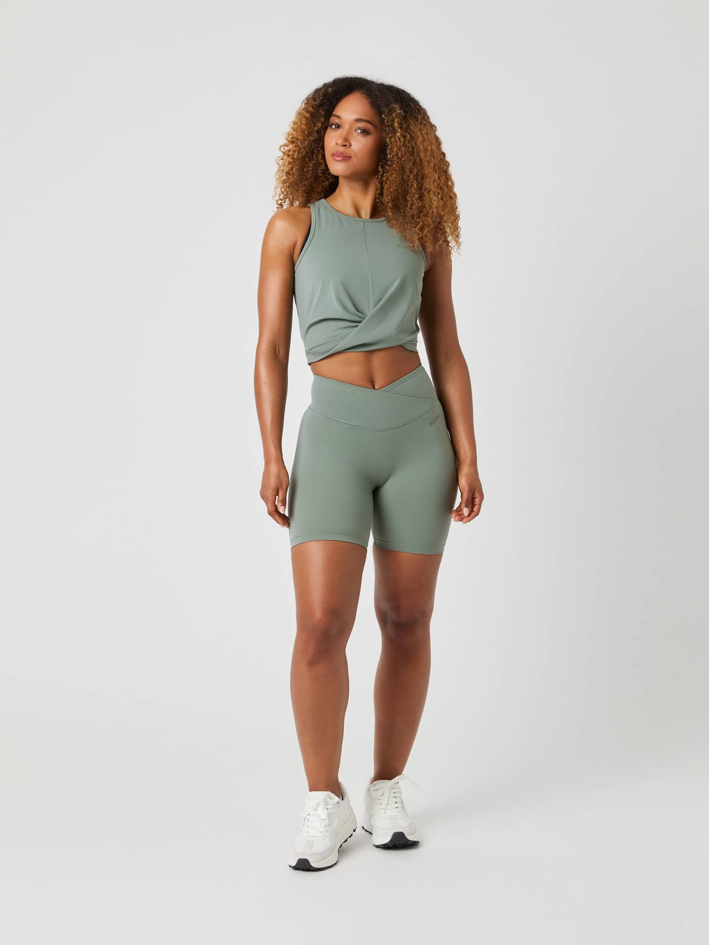 Full-body front view of a model in Björn Borg Studio Cross Shorts in Agave Green (Green) for a high waist training fit. - Image 3