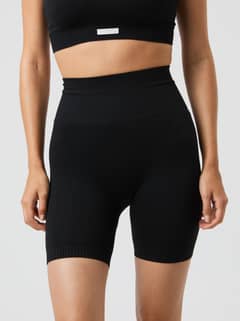 Front view of a model in the rib-knitted, high-waisted Studio Seamless Ribbed Shorts in Black Beauty (Black) for training. - Image 2
