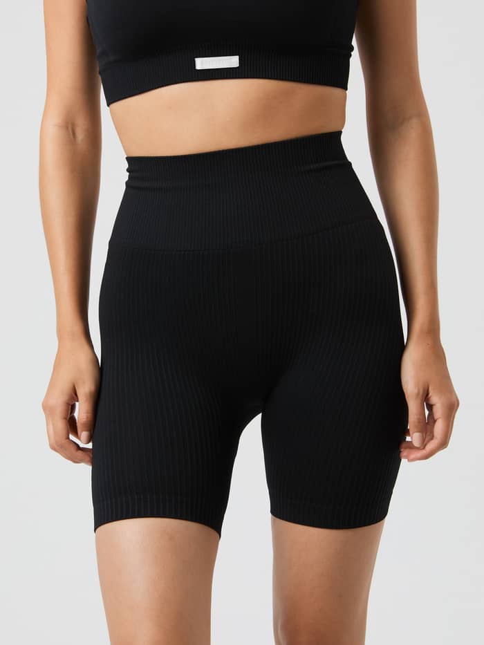 Front view of a model in the rib-knitted, high-waisted Studio Seamless Ribbed Shorts in Black Beauty (Black) for training. - Image 2
