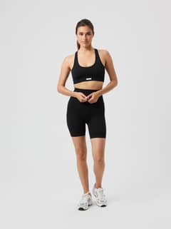 Full-body front view of a model in the high-waisted Studio Seamless Ribbed Shorts in Black Beauty (Black) for training. - Image 1