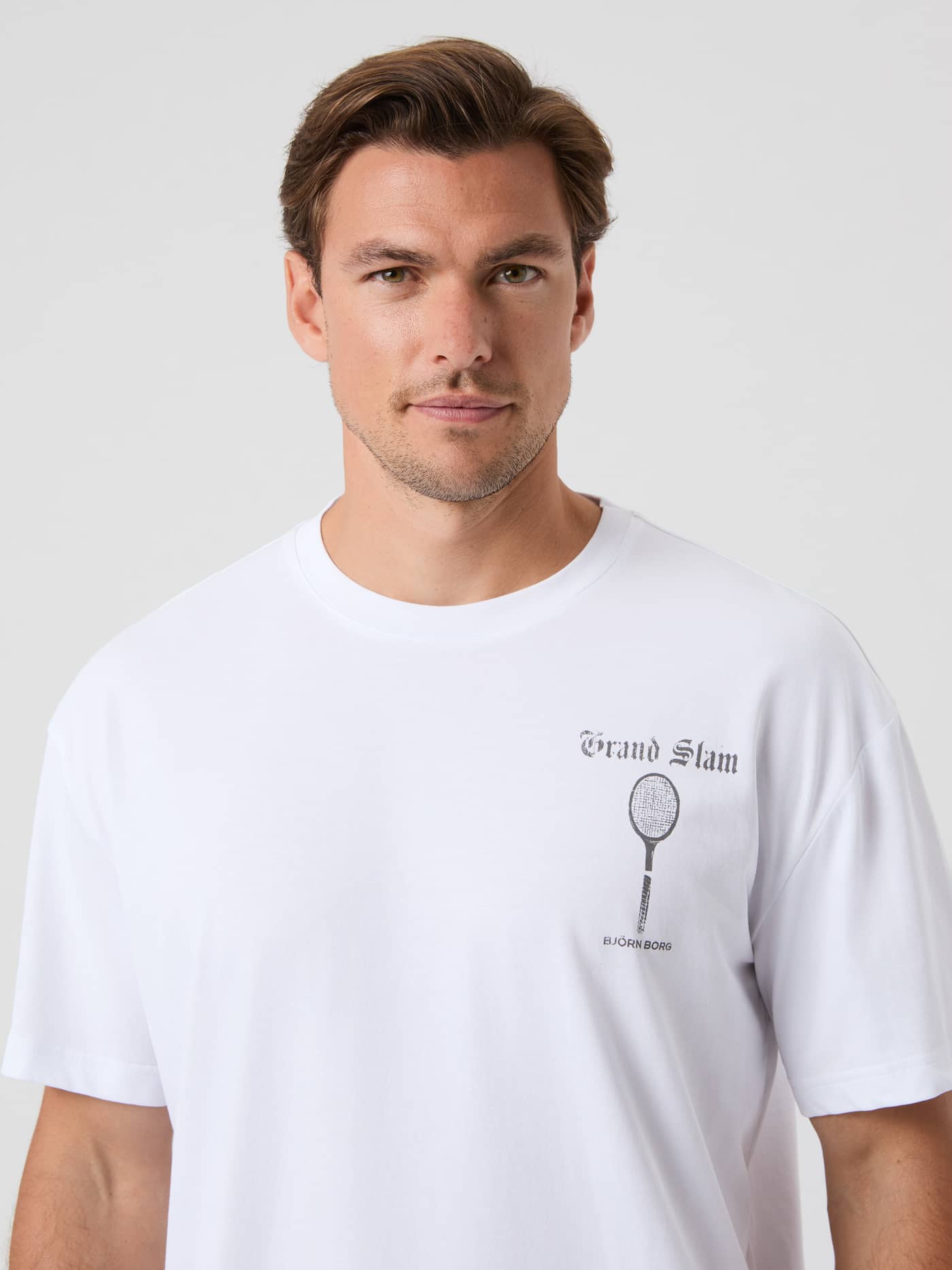 Ace Oversized T-Shirt i Brilliant White (Hvid) set forfra i nærbillede med et sort vintage tennislogo. - Image 2