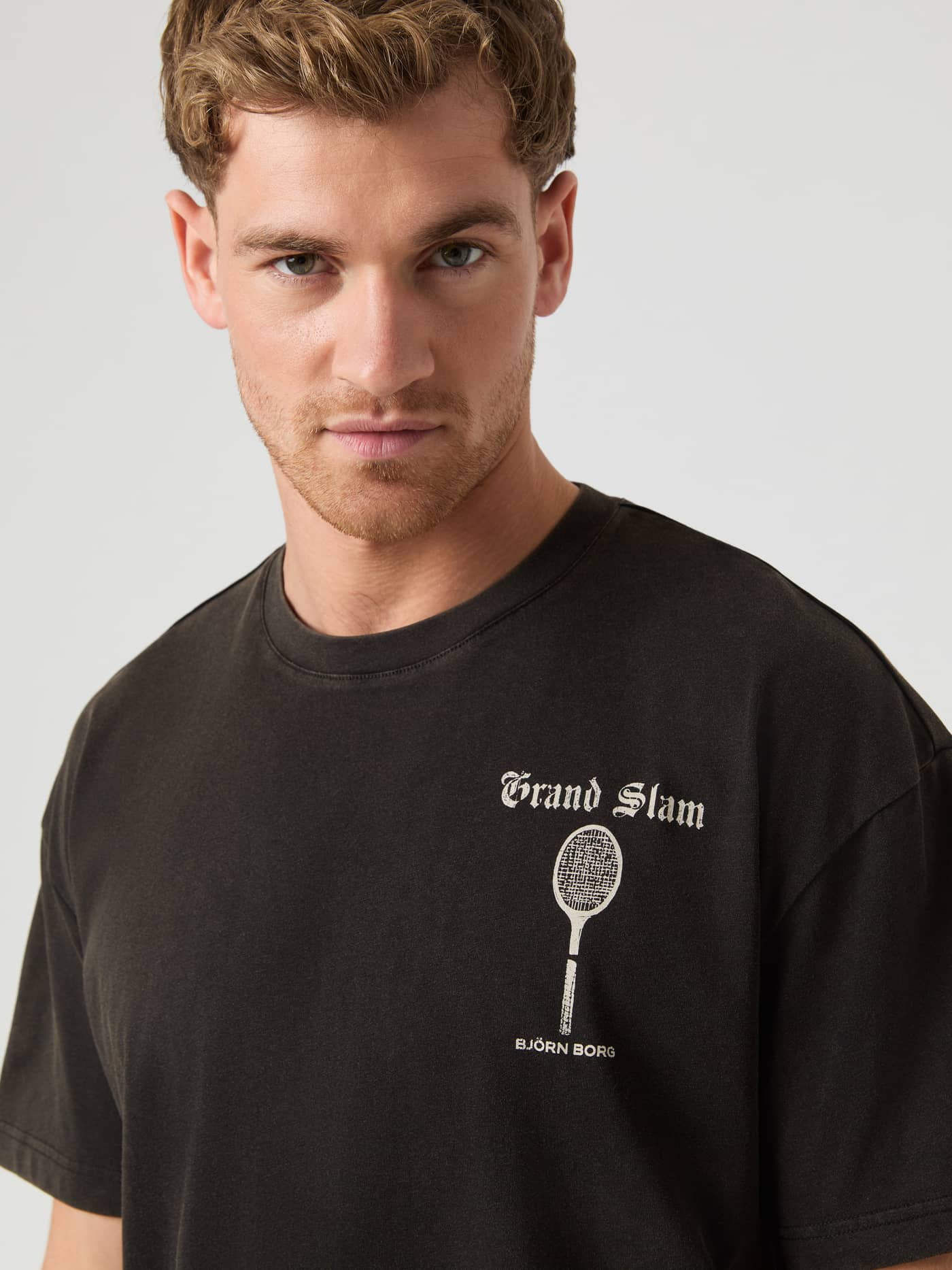 Nærbillede af Ace Oversized T-Shirt i snevasket Black Beauty (Sort) med et hvidt tennisinspireret logo. - Image 2
