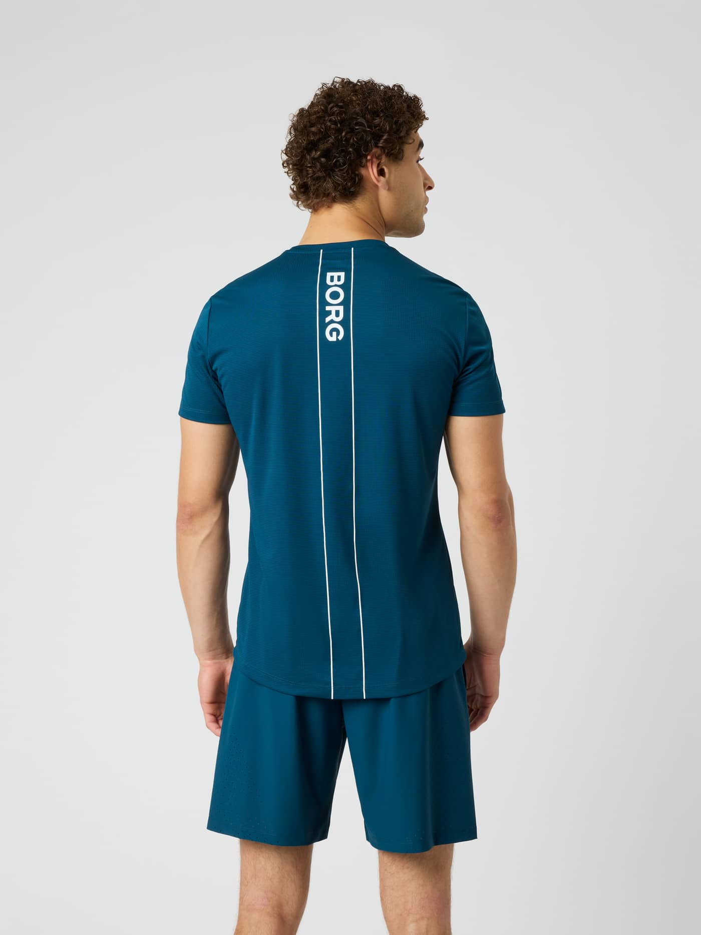 Back view of the Ace Light T-Shirt in Reflecting Pond (Green) with a white Borg logo stripe, ideal for tennis. - Image 2