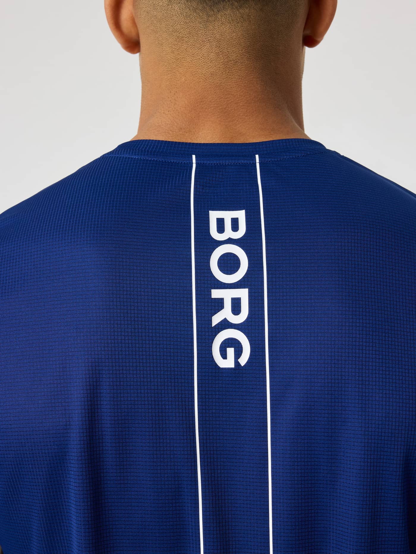 Ace Light T-Shirt i Blue Depths (Blå) set bagfra i nærbillede med hvid BORG-logostribe til tennisperformance. - Image 4