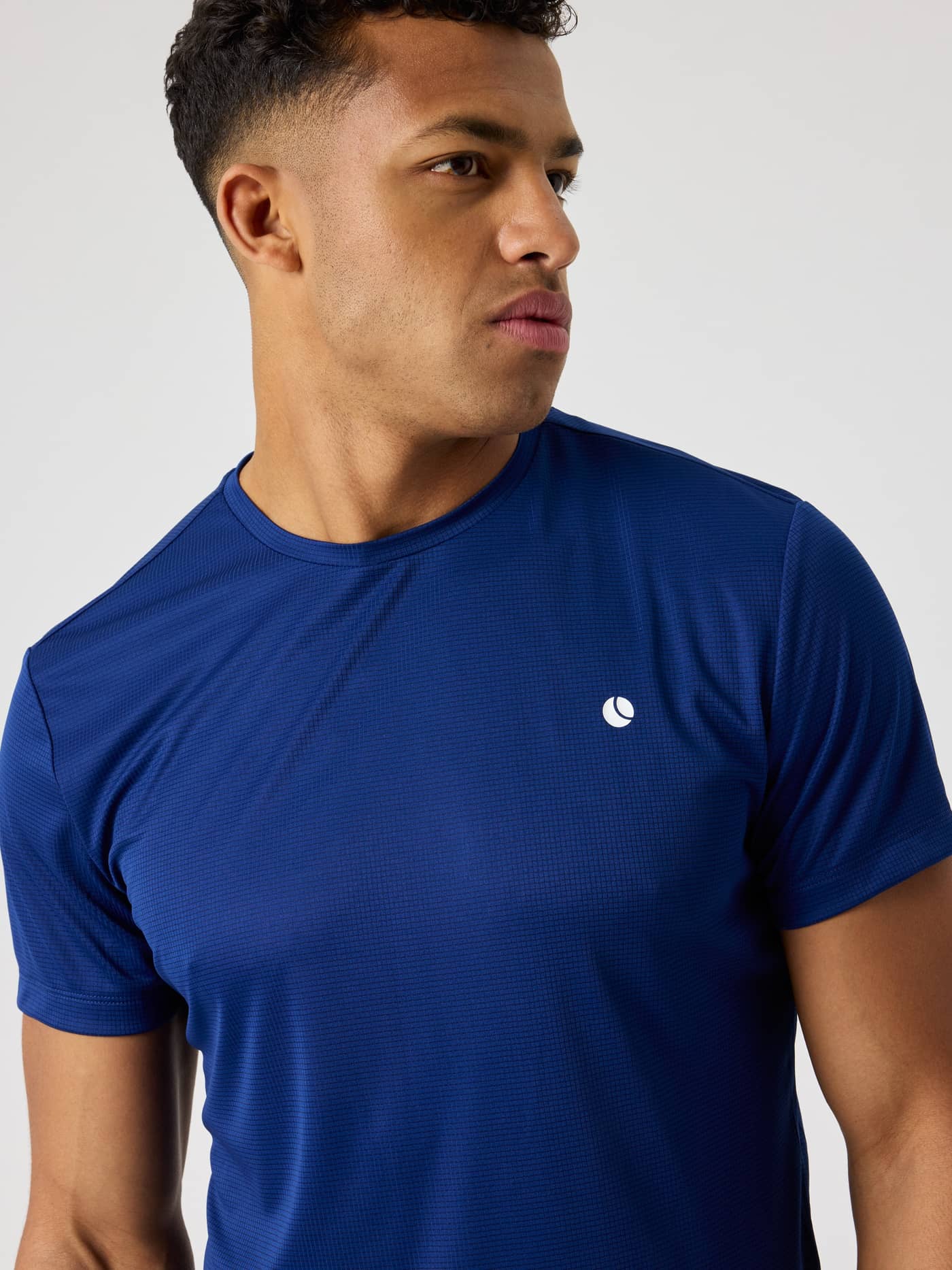 Nærbillede af en mand i Ace Light T-Shirt i Blue Depths (Blå), ideel til åndbar performance til tennis. - Image 5