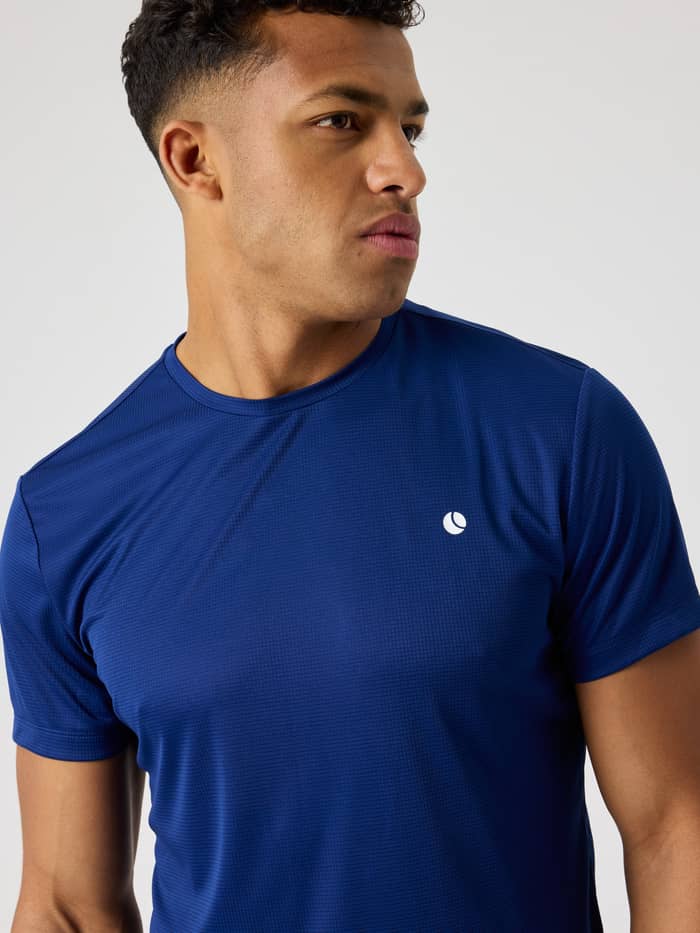 Nærbillede af en mand i Ace Light T-Shirt i Blue Depths (Blå), ideel til åndbar performance til tennis.