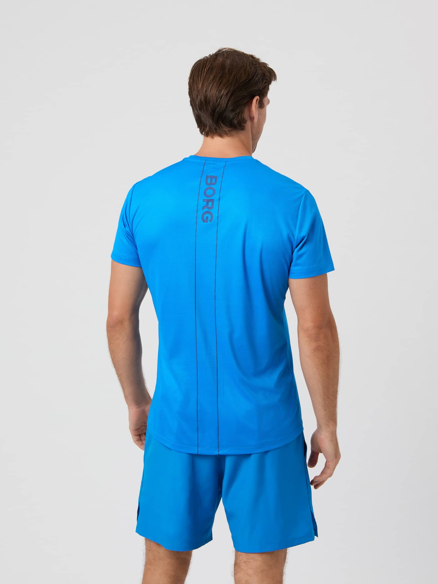 Back view of a male model wearing the Björn Borg Ace Light T-shirt in Electric Blue Lemonade. - Image 2