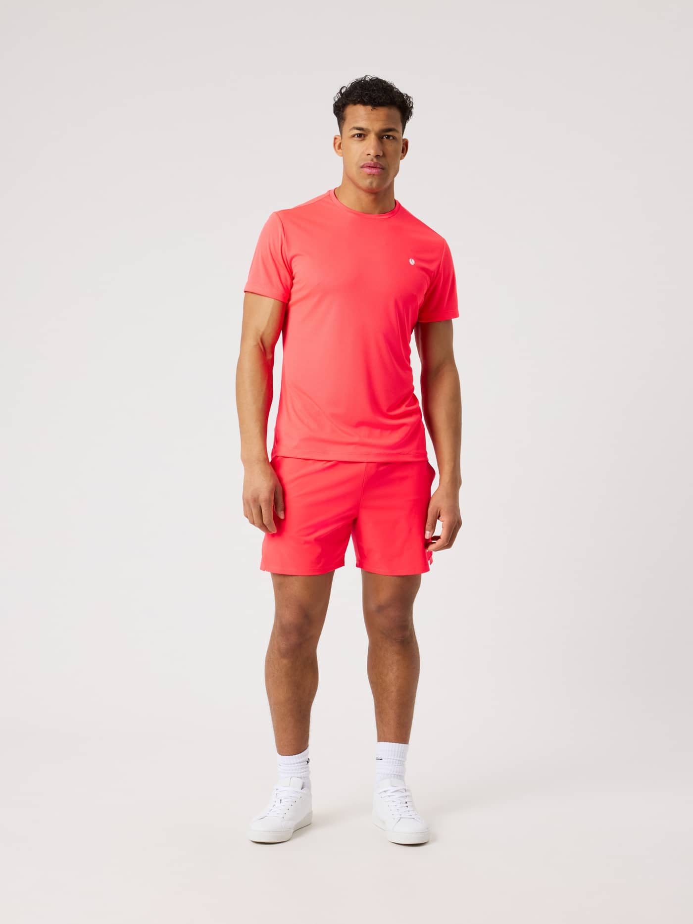 Full-body front view of a man wearing the Diva Pink (Pink) Ace Light T-Shirt, a functional performance top for tennis. - Image 3